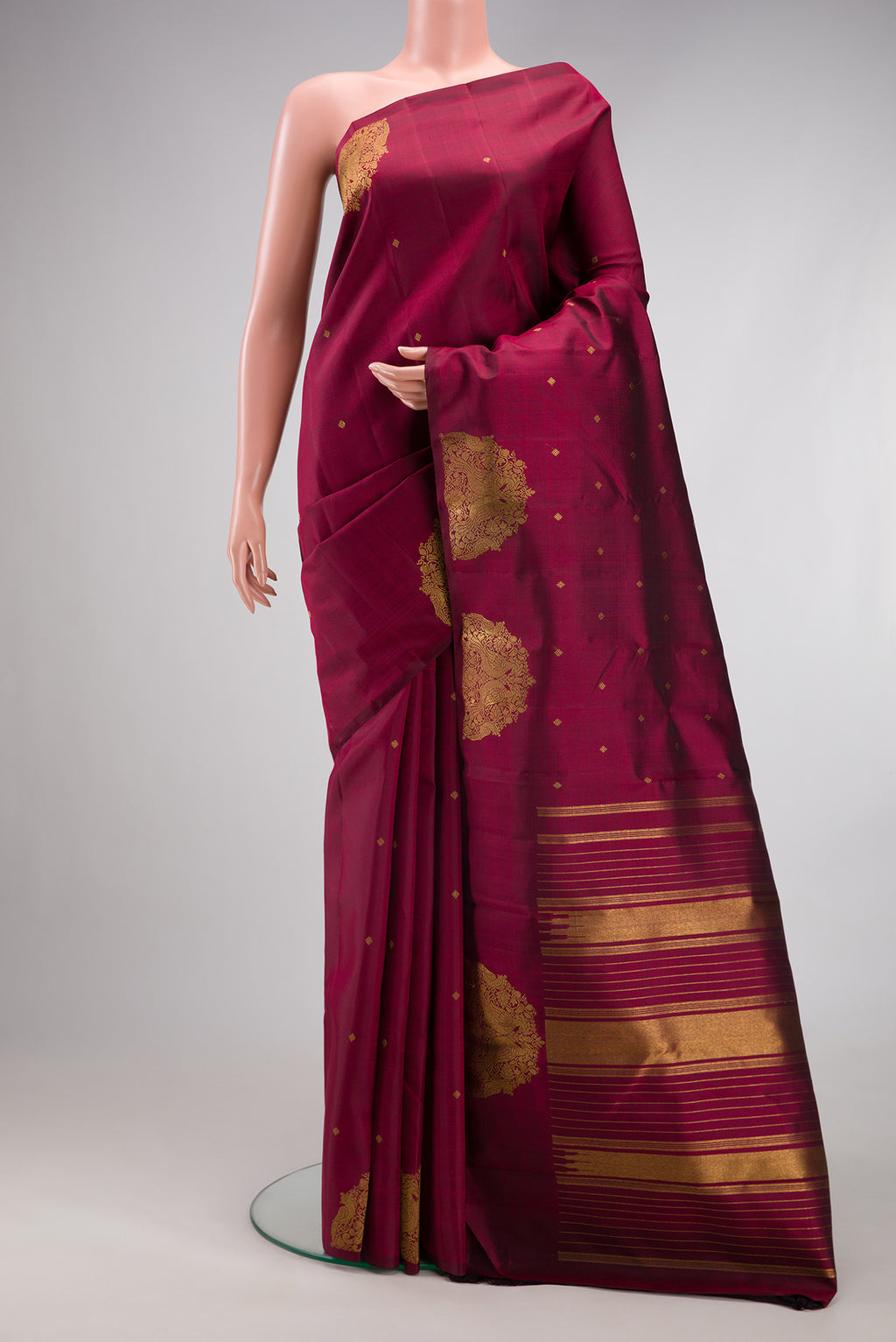 Pure Silk Pure Zari Maroon Kanchipuram Saree with Zari Butta on the body and Fancy Border.  displayed on a mannequin