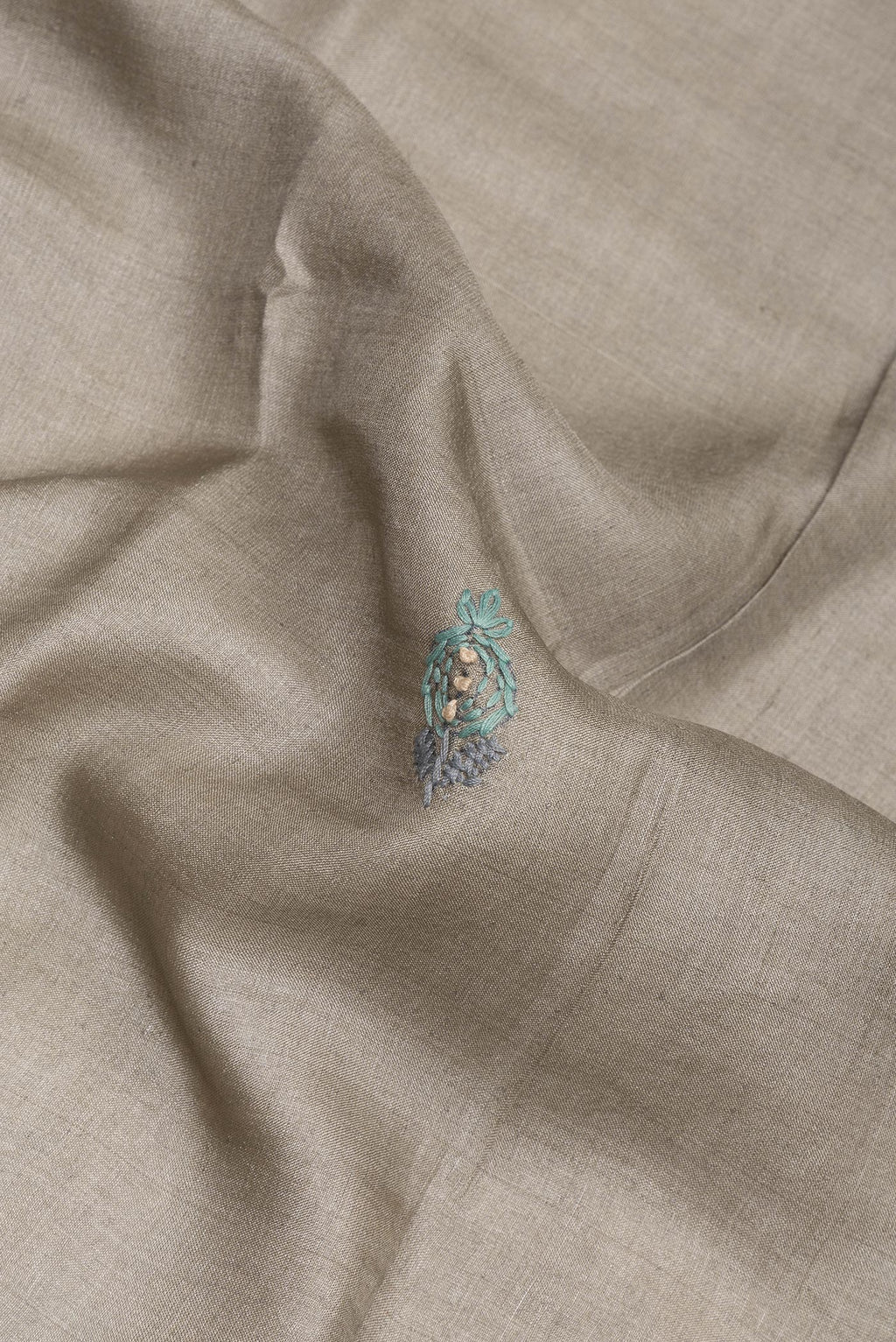 Close up of Grey Tussar Saree with Embroidery on the body and Embroidery Border.  displaying folds