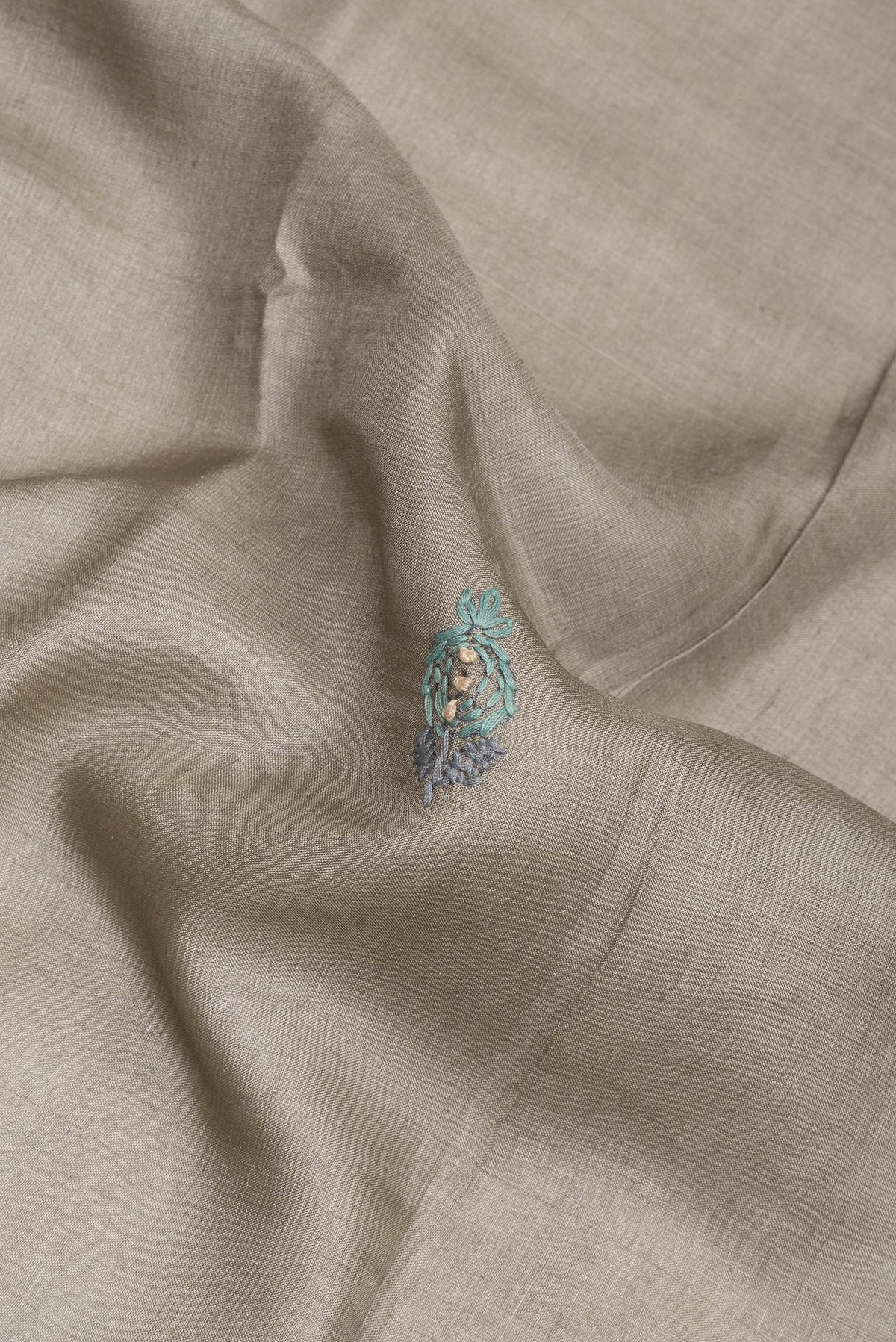 Close up of Grey Tussar Saree with Embroidery on the body and Embroidery Border.  displaying folds