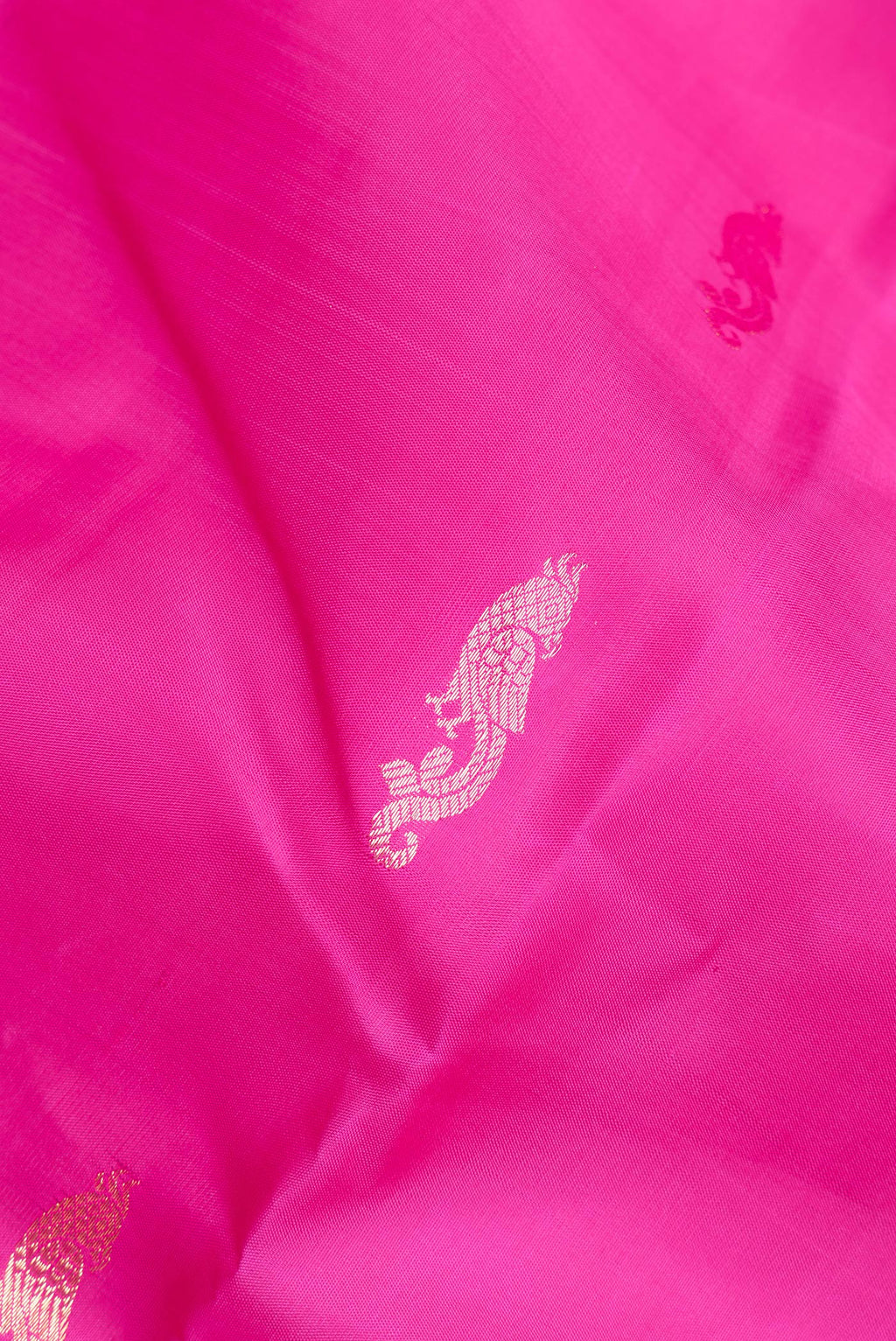 Close up of Pure Silk Dark Pink Kanchipuram Saree with Zari Butta on the body and Fancy Border.  displaying folds