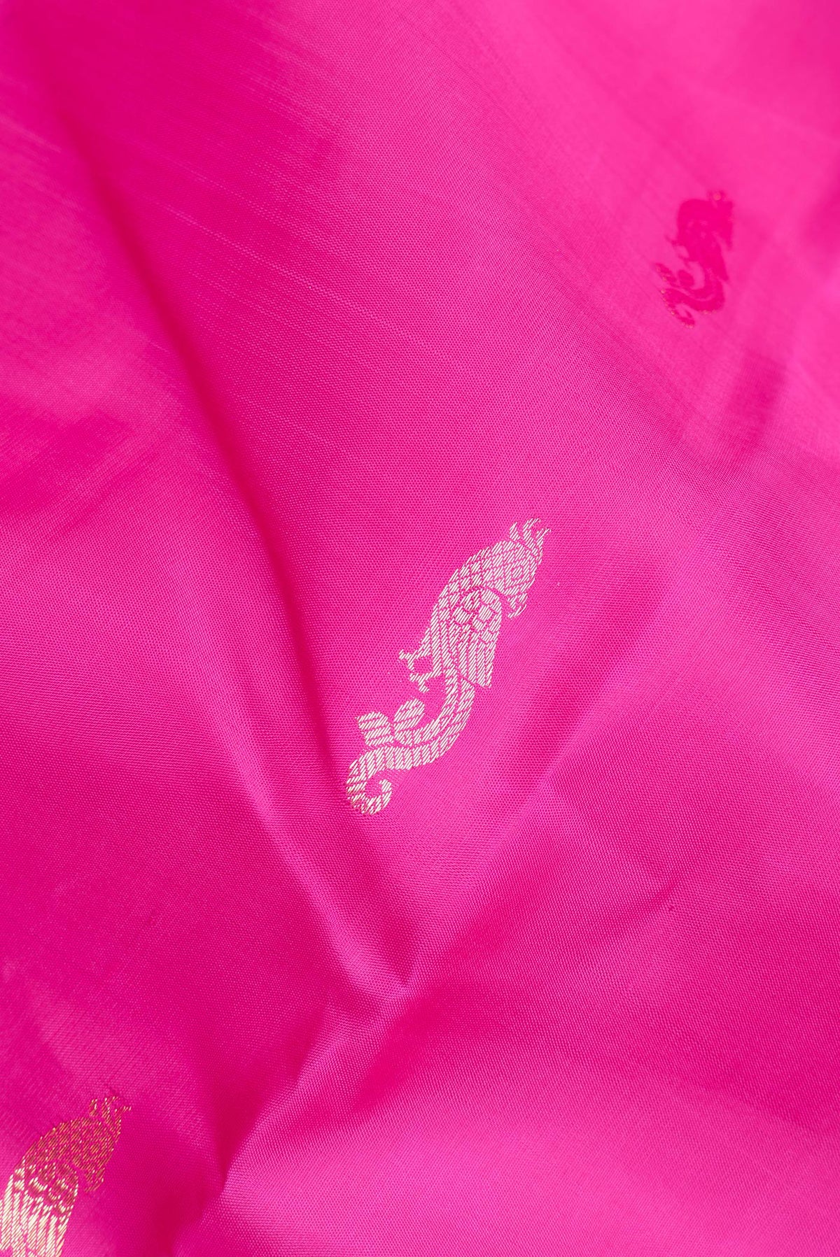 Close up of Pure Silk Dark Pink Kanchipuram Saree with Zari Butta on the body and Fancy Border.  displaying folds