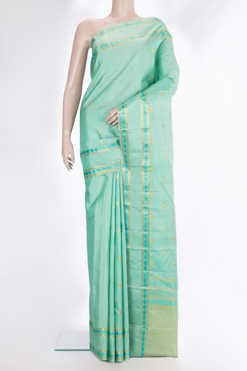 Pure Silk Pista Green Kanchipuram Saree with Zari Butta on the body and Zari And Thread Border.  displayed on a mannequin