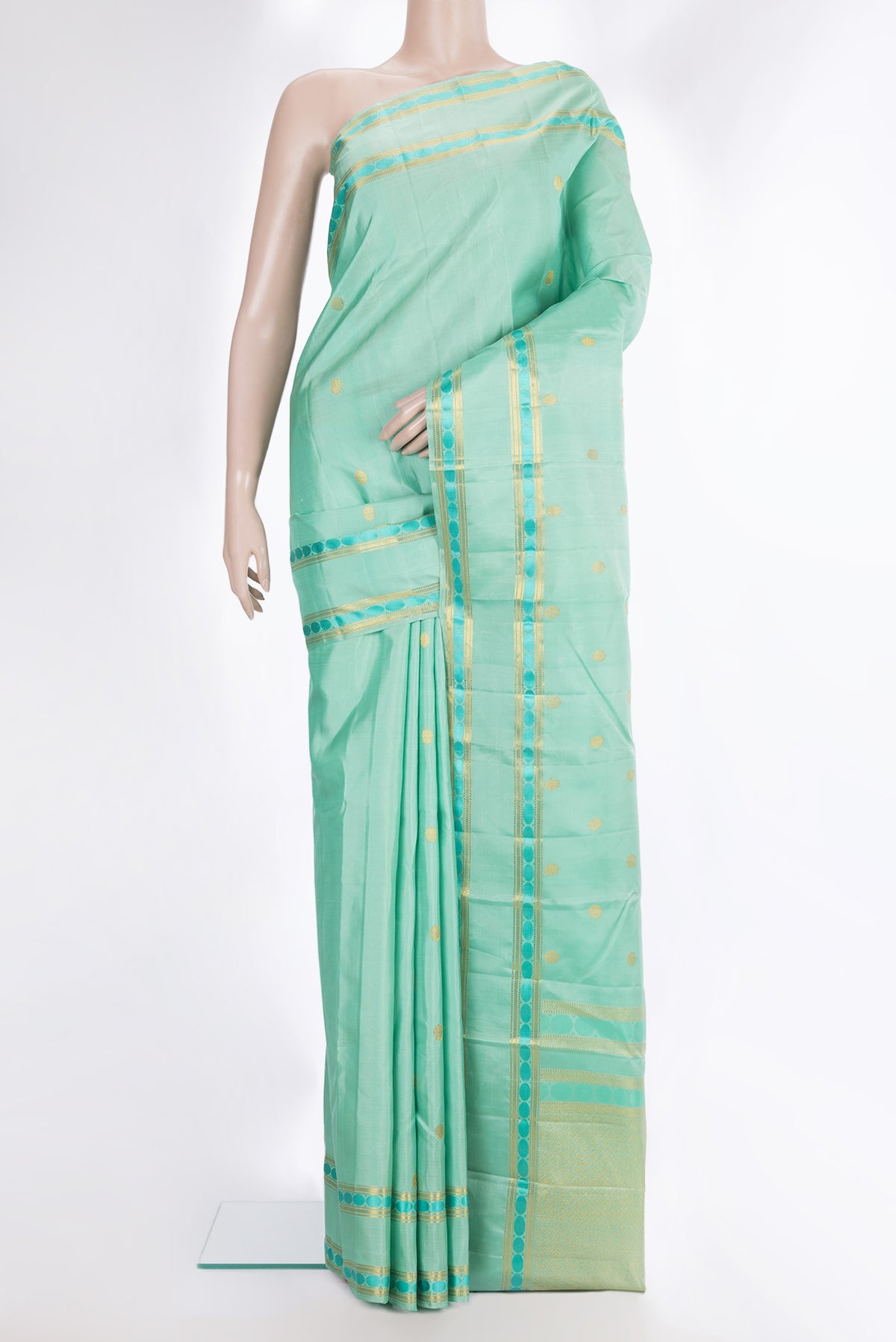 Pure Silk Pista Green Kanchipuram Saree with Zari Butta on the body and Zari And Thread Border.  displayed on a mannequin