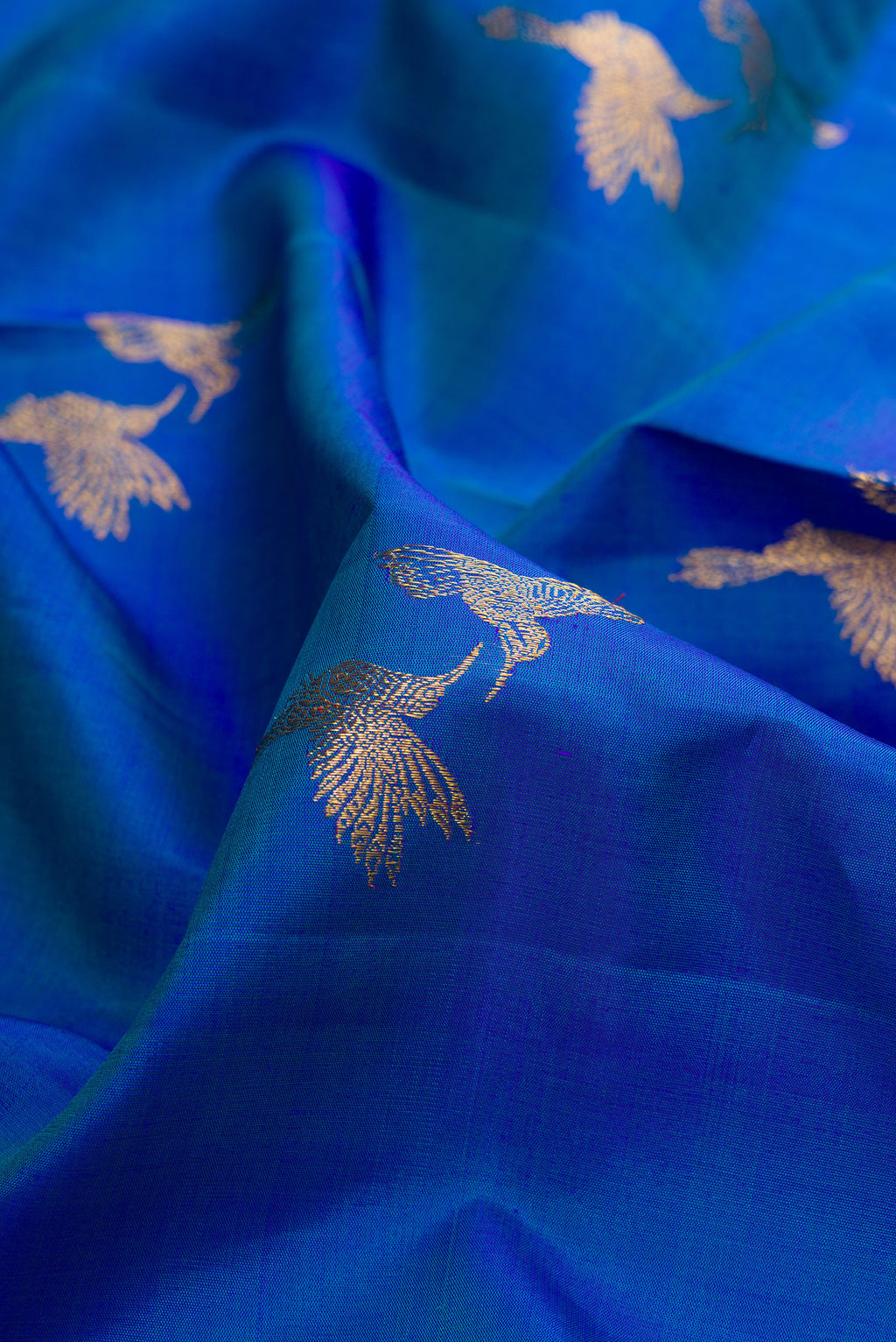 Close up of Pure Silk Peacock Blue Dual Tone Kanjivaram Saree with Zari Butta on the body and Zari Border.  displaying folds