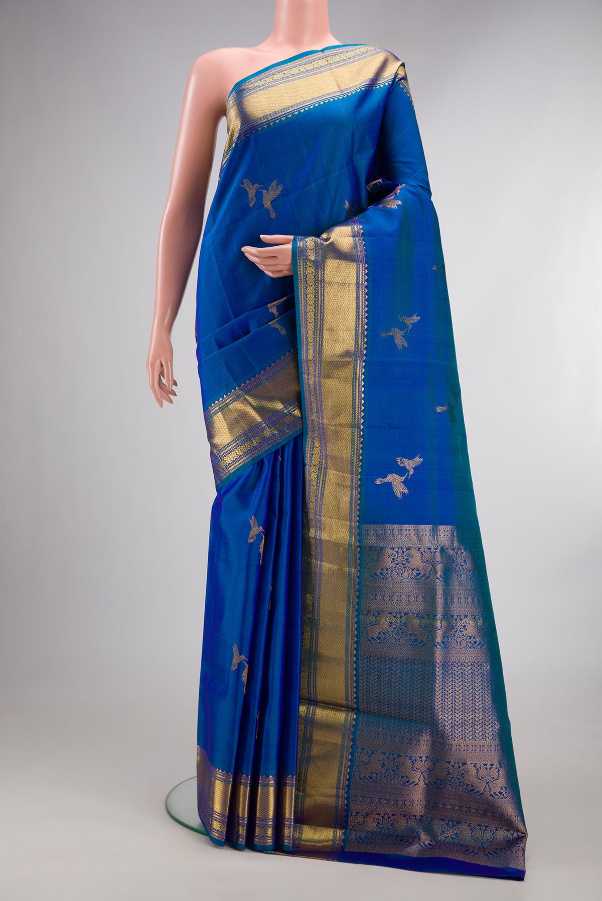 Pure Silk Peacock Blue Dual Tone Kanjivaram Saree with Zari Butta on the body and Zari Border.  displayed on a mannequin