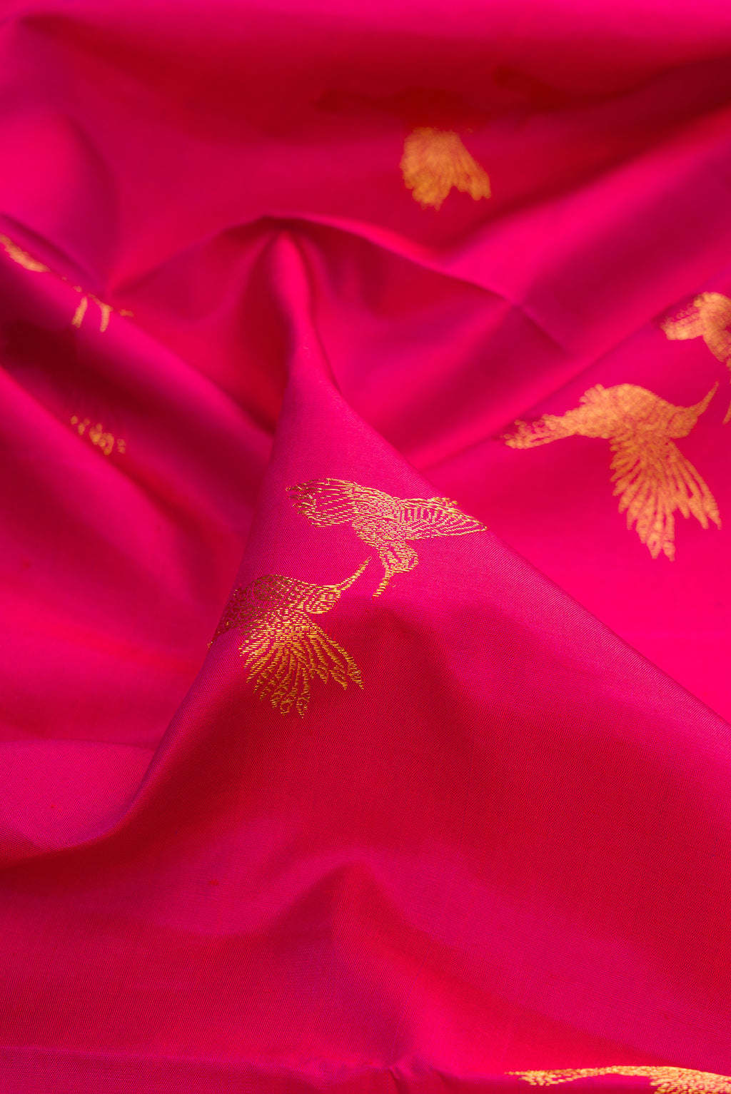 Close up of Pure Silk Dark Pink Dual Tone Kanjivaram Saree with Zari Butta on the body and Zari Border.  displaying folds
