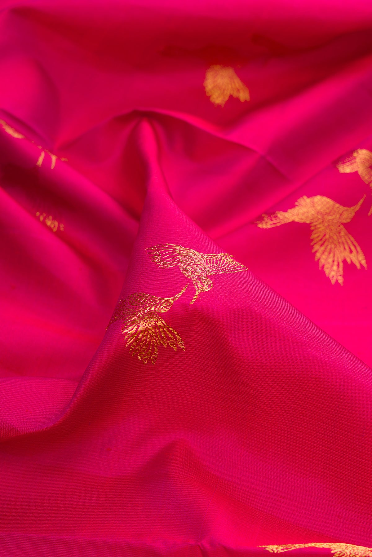 Close up of Pure Silk Dark Pink Dual Tone Kanjivaram Saree with Zari Butta on the body and Zari Border.  displaying folds
