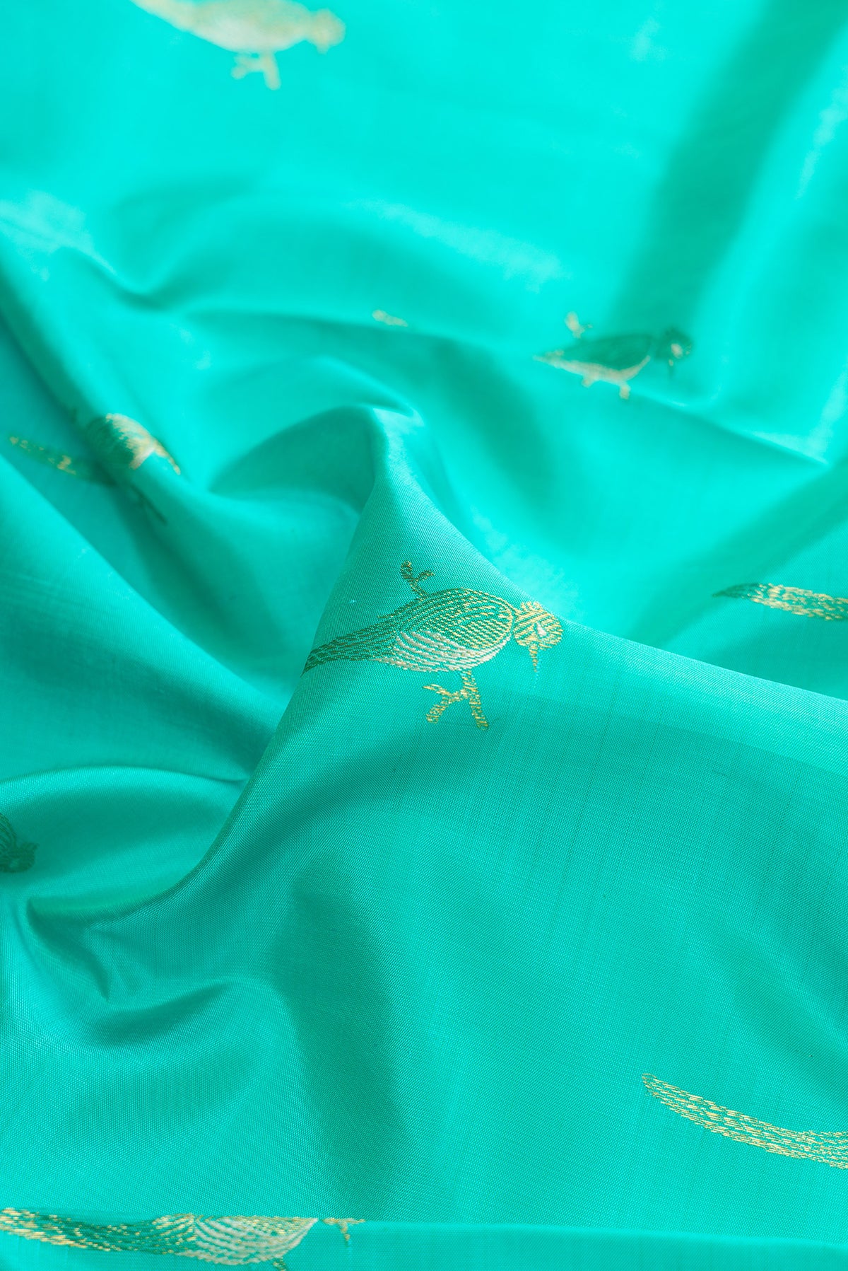 Close up of Pure Silk Sea Green Kanjivaram Saree with Zari Butta on the body and Zari Border.  displaying folds