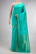 Pure Silk Sea Green Kanjivaram Saree with Zari Butta on the body and Zari Border.  displayed on a mannequin