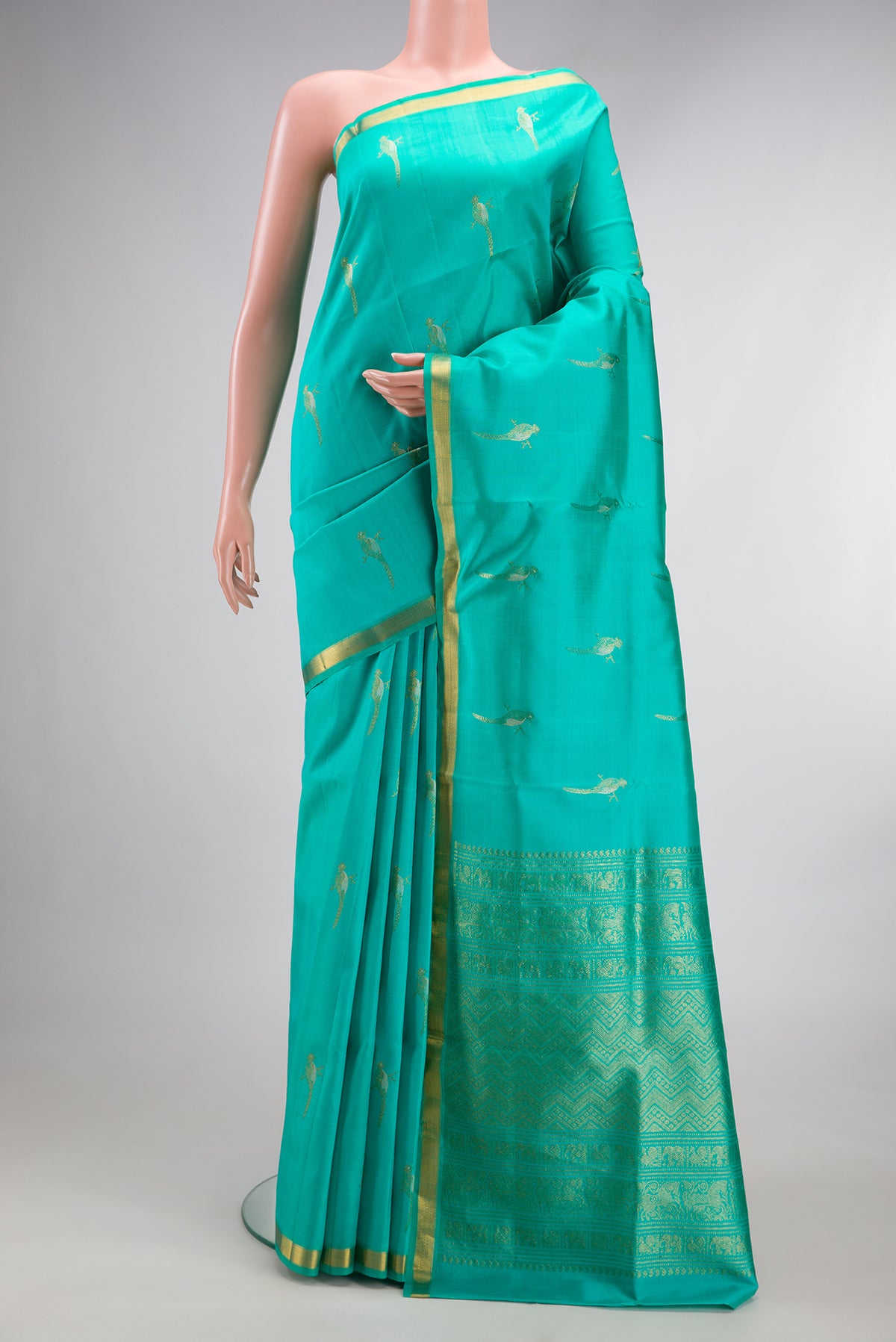 Pure Silk Sea Green Kanjivaram Saree with Zari Butta on the body and Zari Border.  displayed on a mannequin