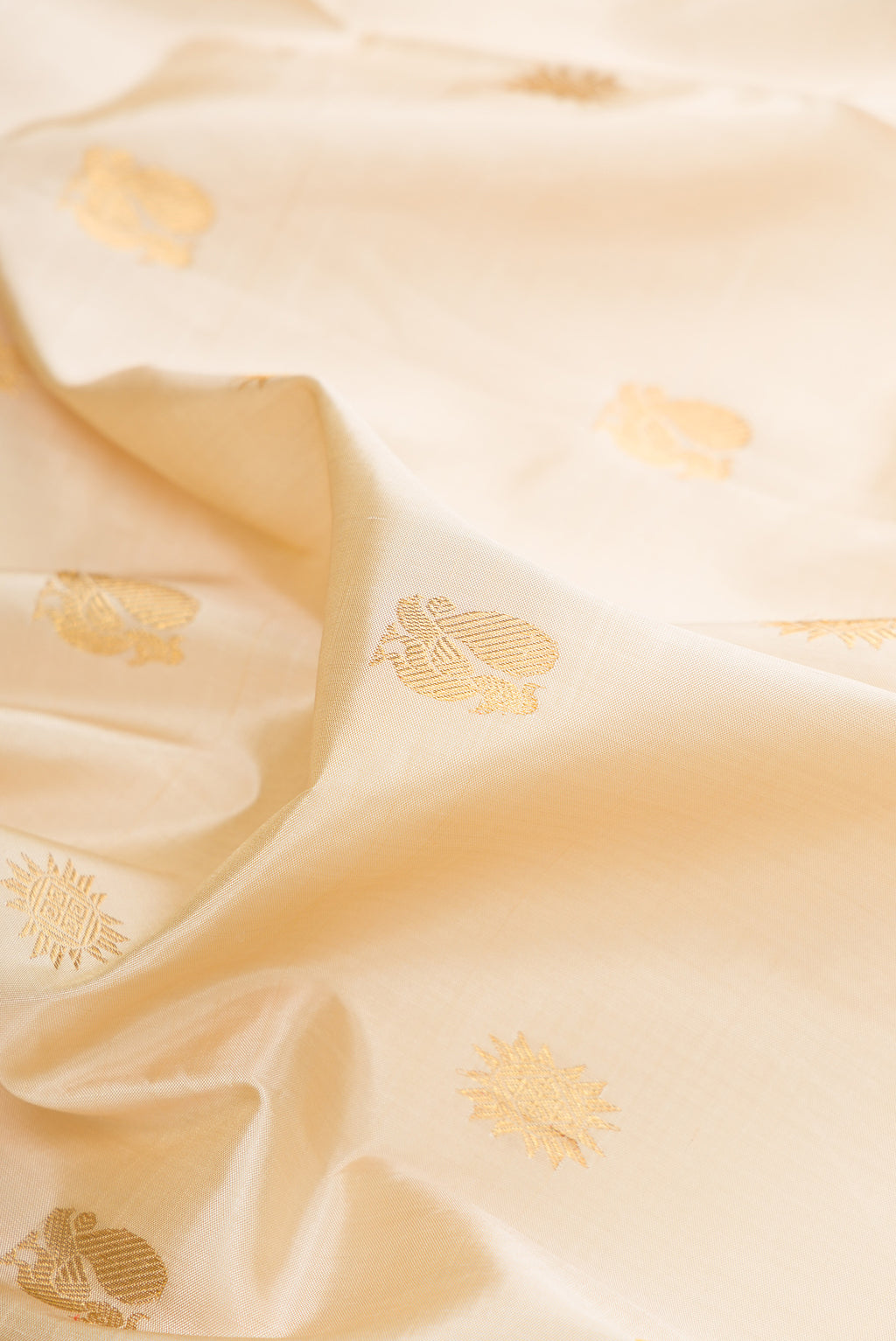 Close up of Pure Silk Beige Kanjivaram Saree with Zari Butta on the body and Zari Border.  displaying folds