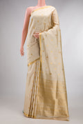 Pure Silk Beige Kanjivaram Saree with Zari Butta on the body and Zari Border.  displayed on a mannequin