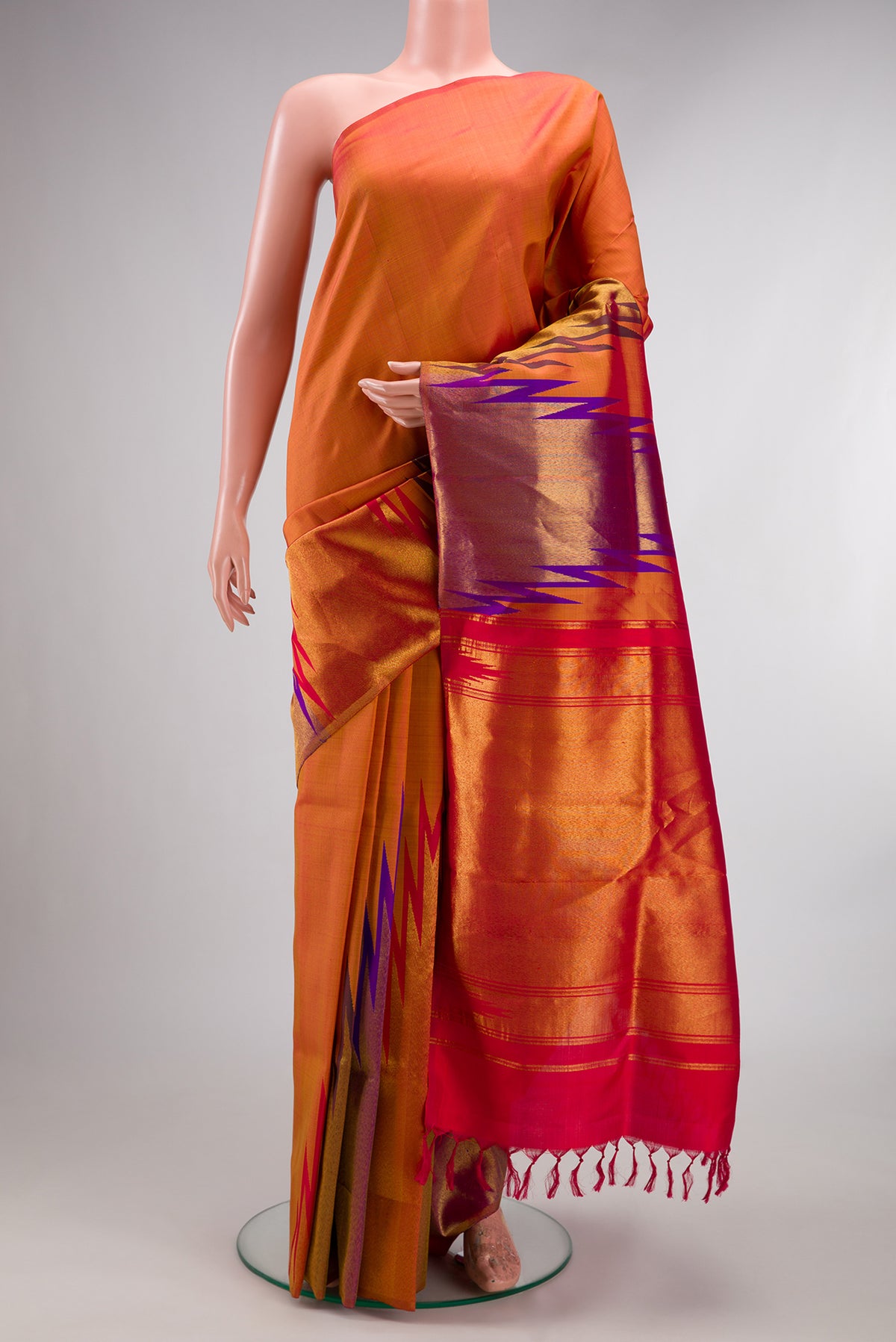 Pure Silk Brick Orange Dual Tone Kanchipuram Saree with Plain Body and Temple Border.  displayed on a mannequin