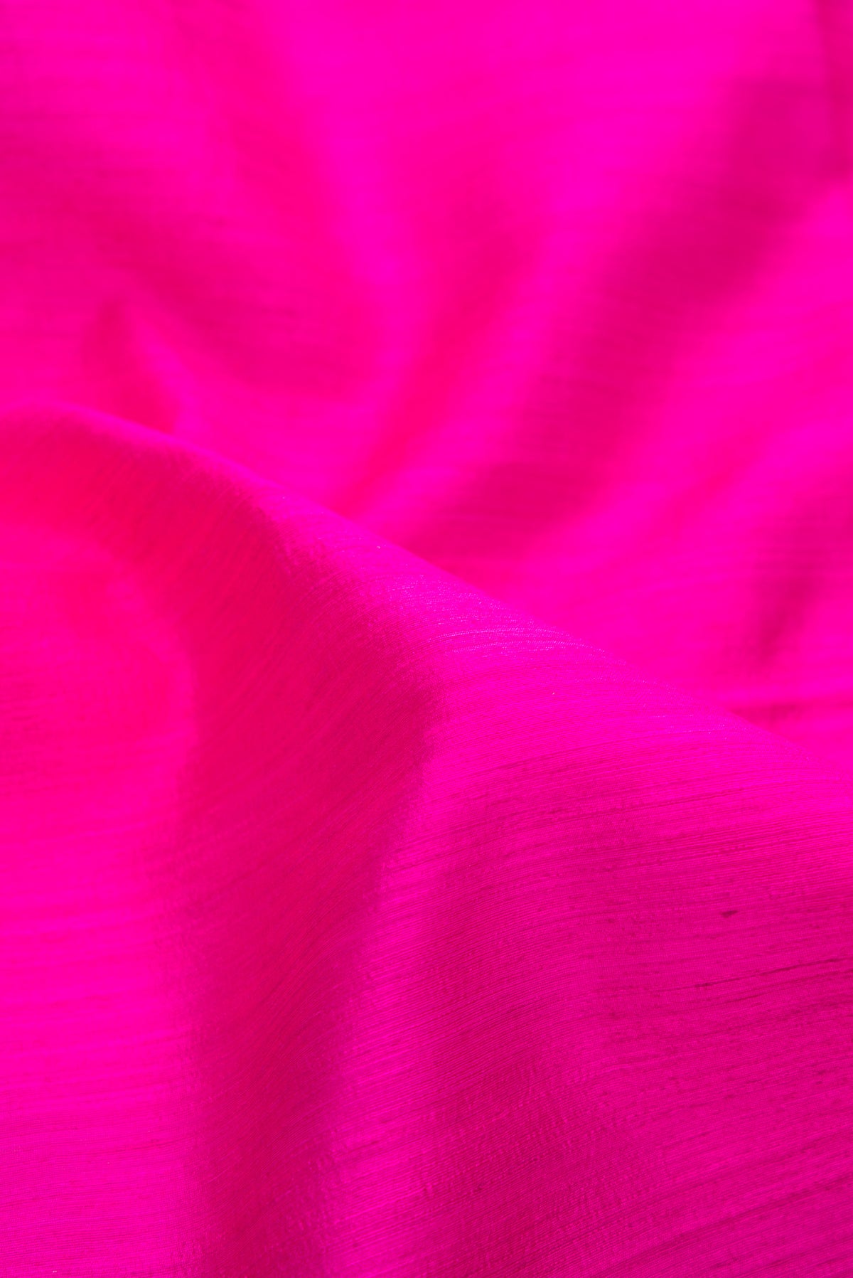 Close up of Pure Silk Pink Tussar Saree with Plain Body and Thin Zari Line.  displaying folds