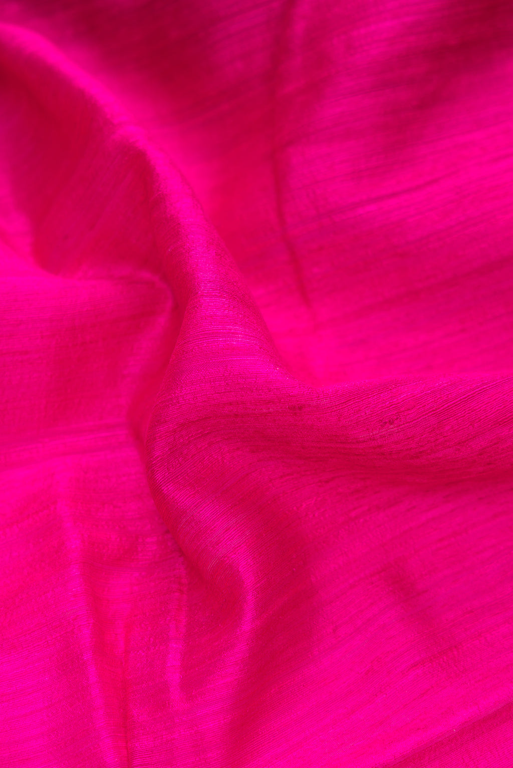 Close up of Pure Silk Dark Pink Dual Tone Tussar Saree with Plain Body and Thin Zari Line.  displaying folds