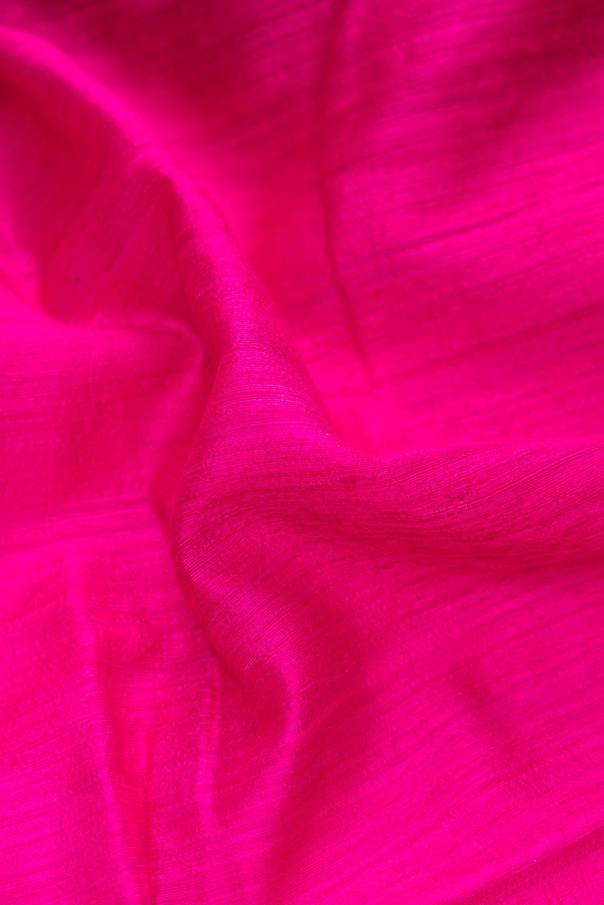 Close up of Pure Silk Dark Pink Dual Tone Tussar Saree with Plain Body and Thin Zari Line.  displaying folds