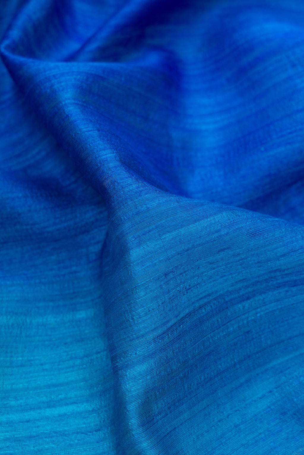Close up of Pure Silk Royal Blue and Sea Green Color Tussar Saree with Ombre design on the body and Without Border.  displaying folds