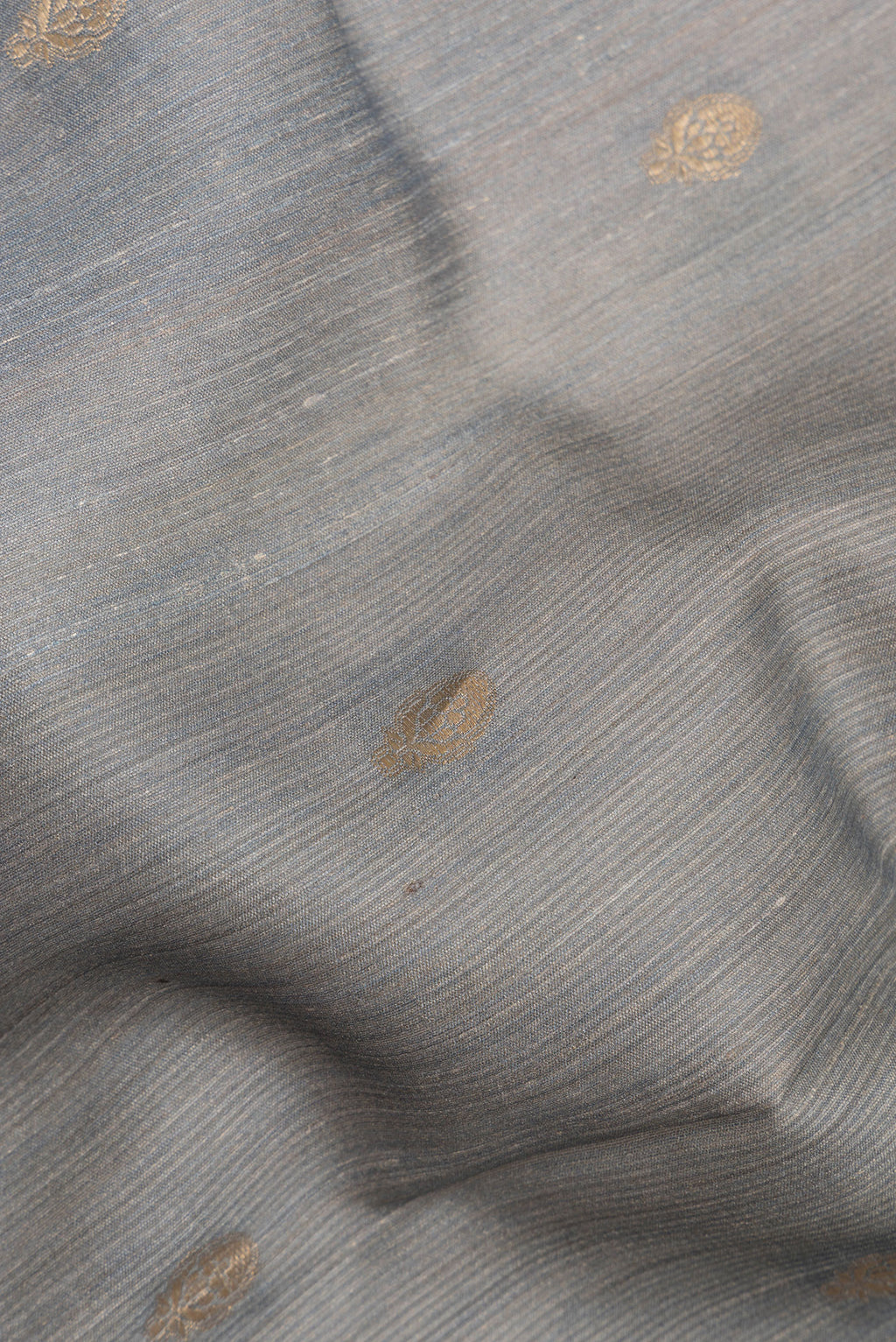 Close up of Grey Tussar Saree with Zari Butta on the body and Fancy Border.  displaying folds