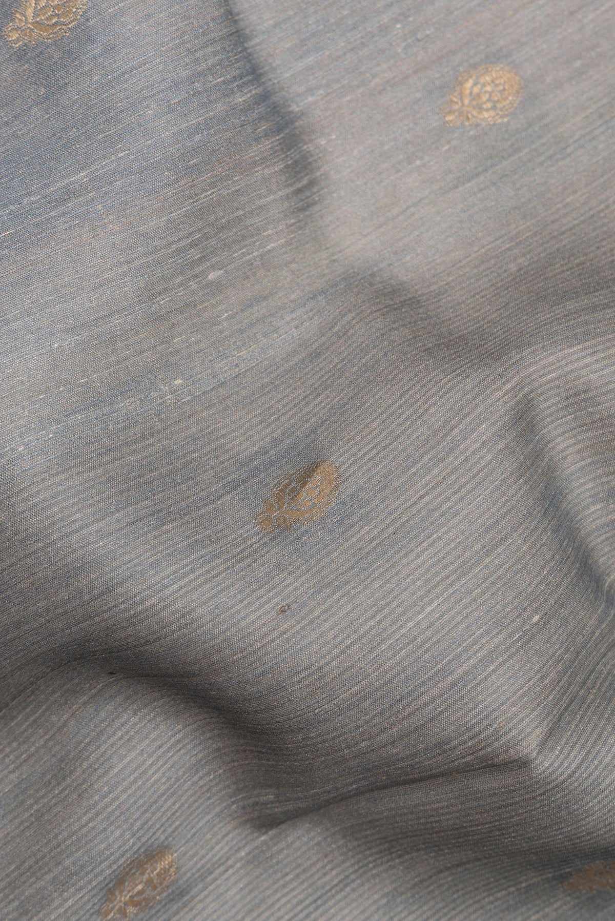 Close up of Grey Tussar Saree with Zari Butta on the body and Fancy Border.  displaying folds