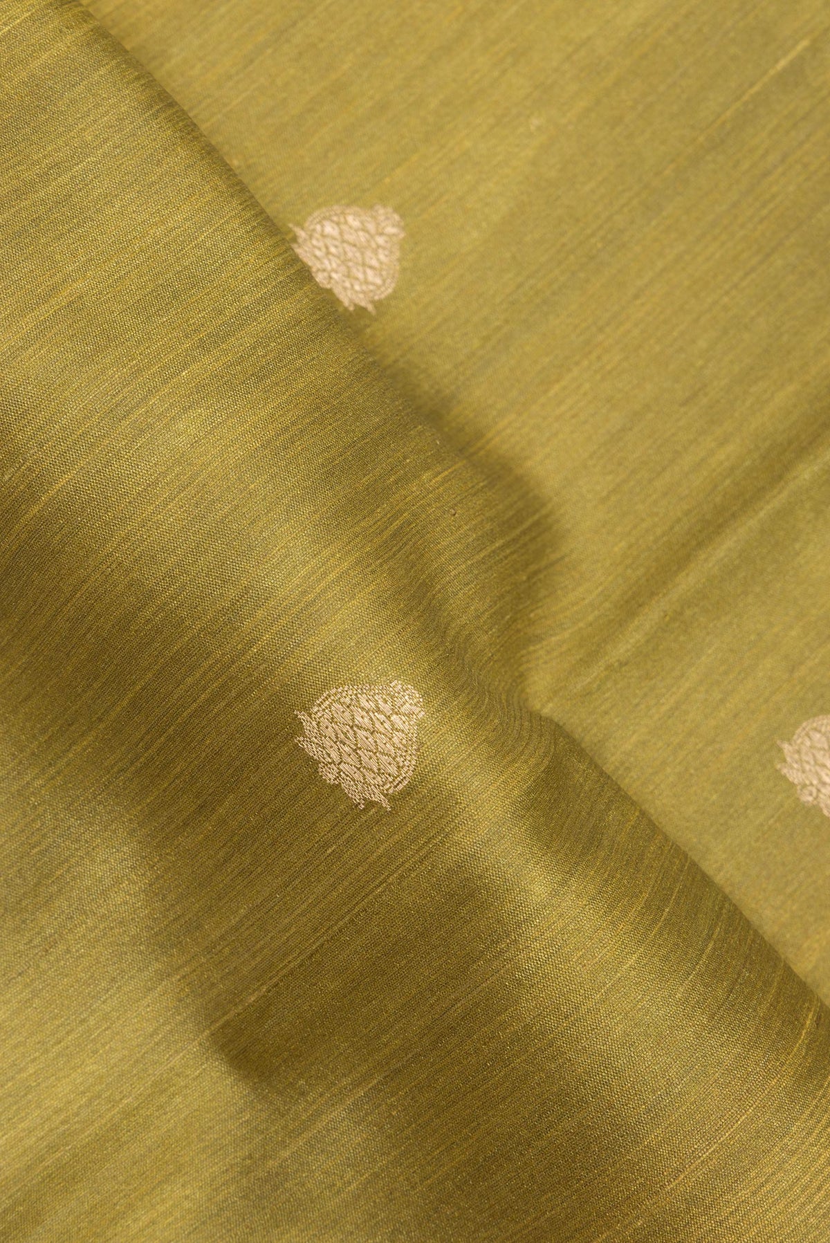 Close up of Mehandi Green Tussar Saree with Zari Butta on the body and Fancy Border.  displaying folds