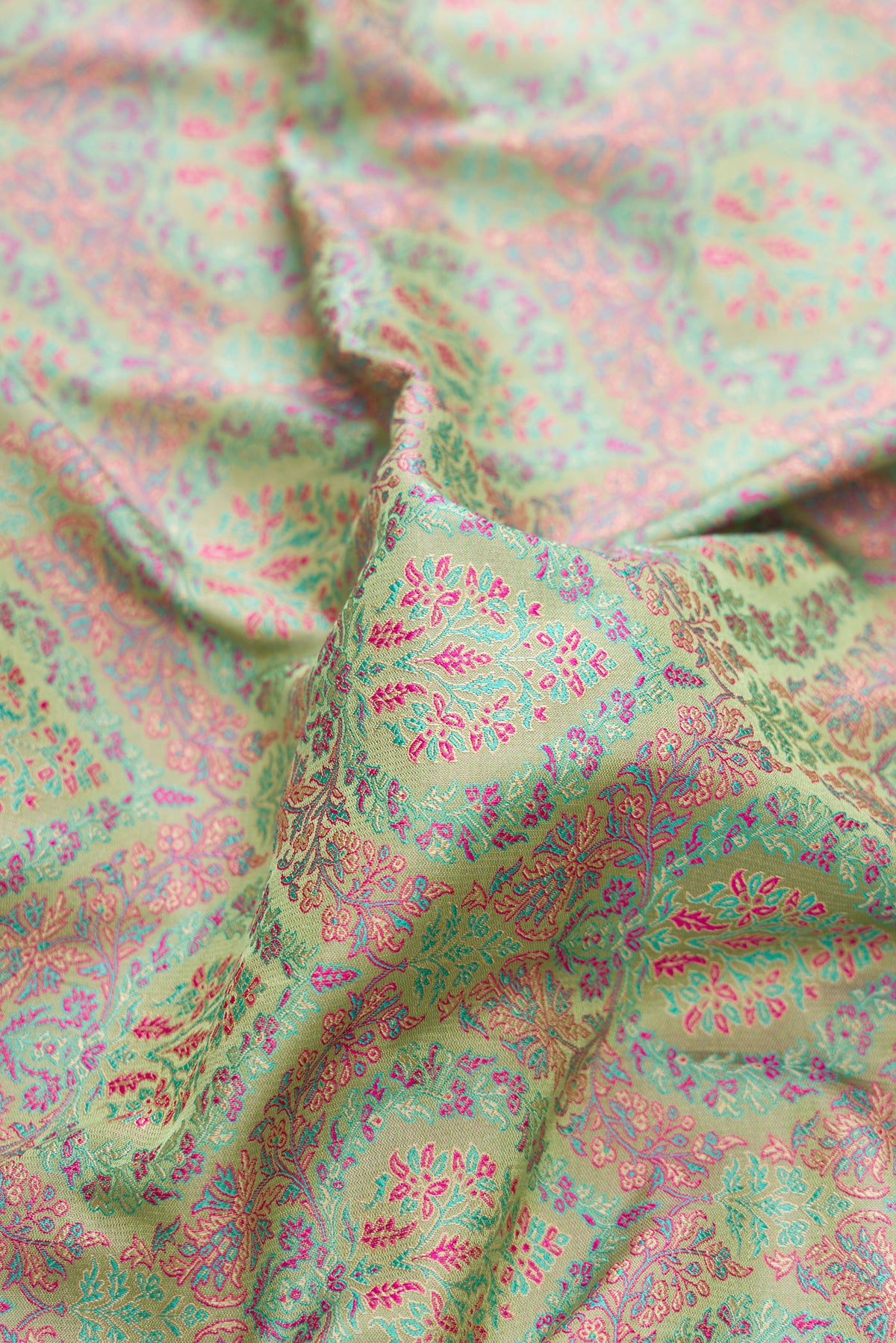 Close up of Pure Silk Pista Green Banarasi Saree with Jacquard design on the body and Thread Border.  displaying folds