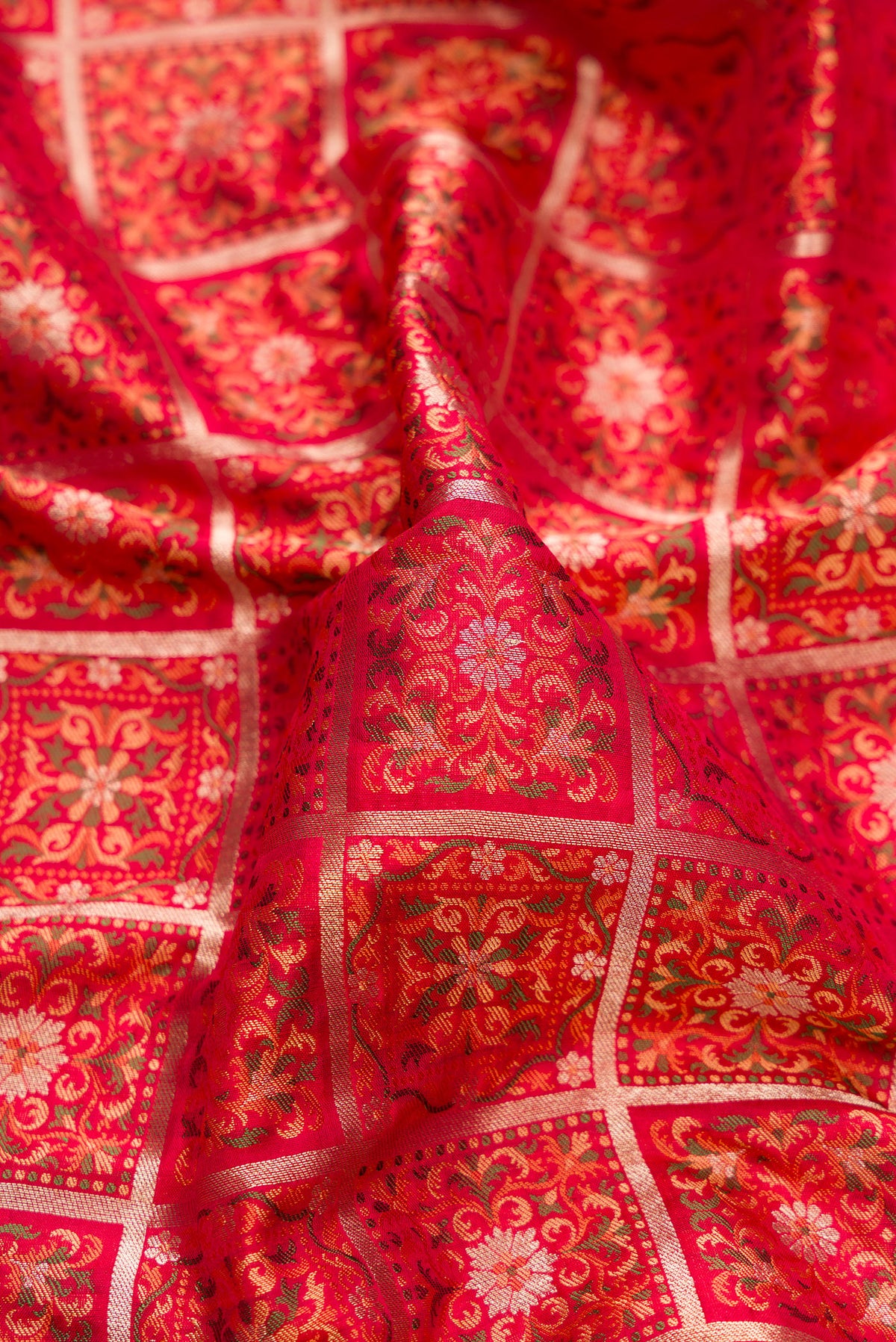 Close up of Pure Silk Red Banarasi Jamavar Saree with Jacquard design on the body and Fancy Border.  displaying folds
