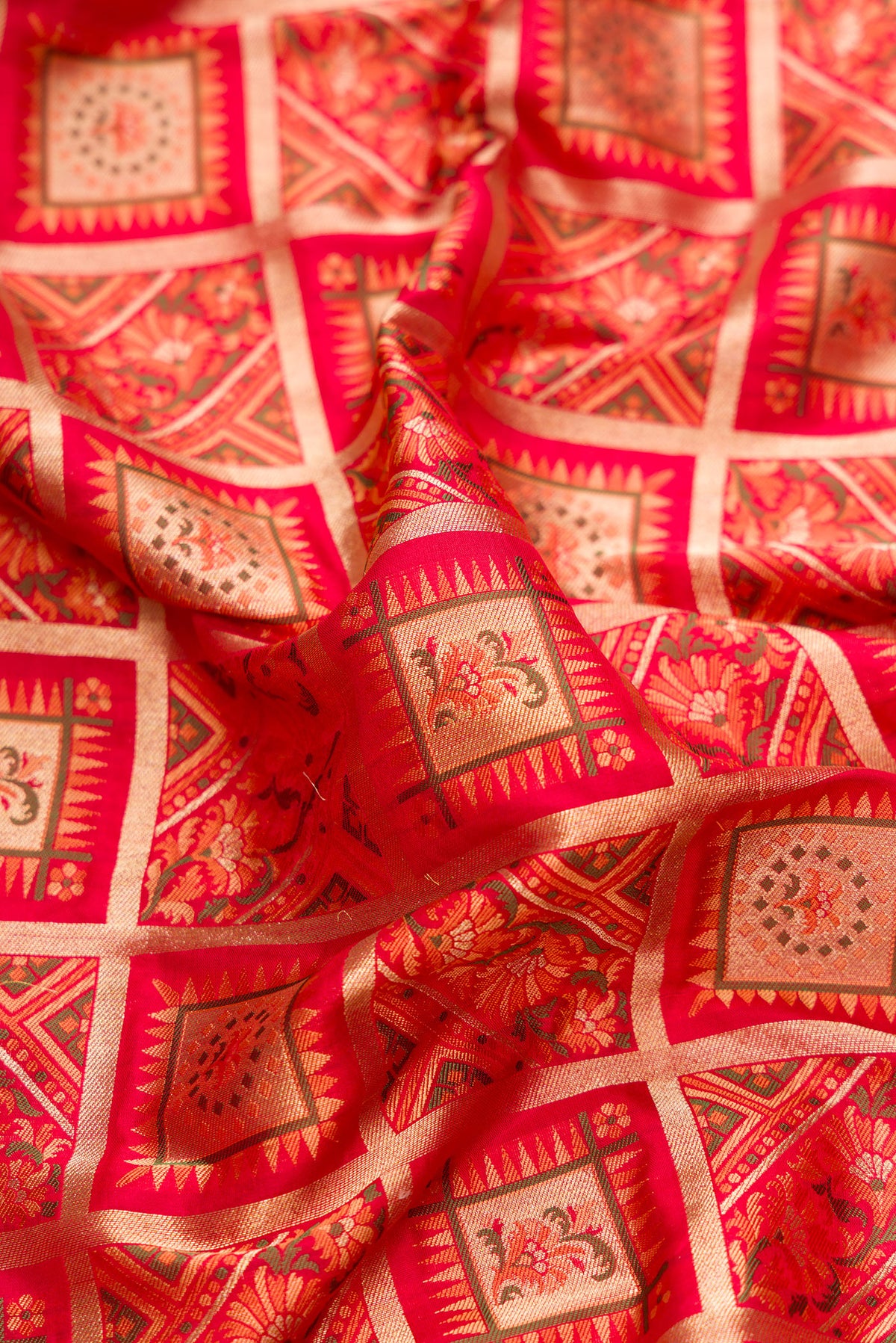 Close up of Pure Silk Red Banarasi Jamavar Saree with Zari Brocade on the body and Zari And Thread Border.  displaying folds