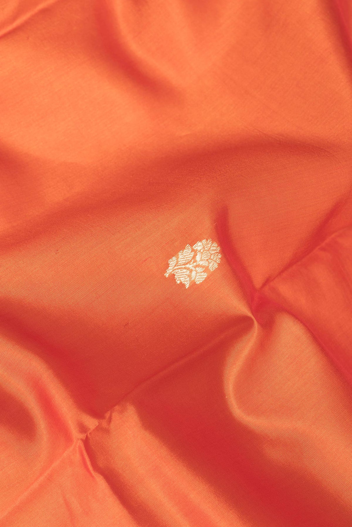 Close up of Pure Silk Orange Dual Tone Tussar Saree with Zari Butta on the body and Fancy Border.  displaying folds