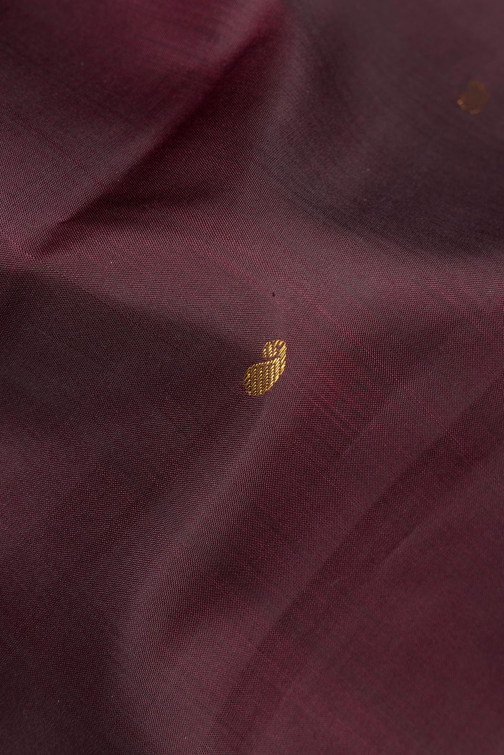 Close up of Pure Silk Brown Kanchipuram Saree with Zari Butta on the body and Zari Border.  displaying folds