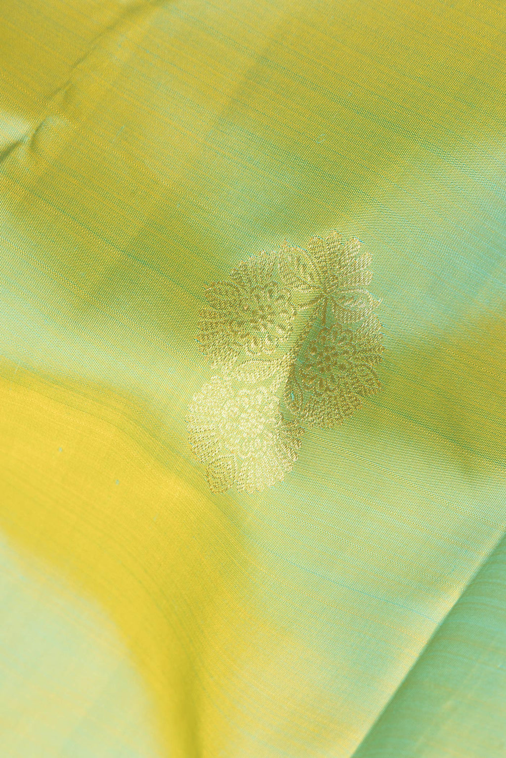 Close up of Pure Silk Pista Green Dual Tone Kanchipuram Saree with Zari Butta on the body and Zari Border.  displaying folds