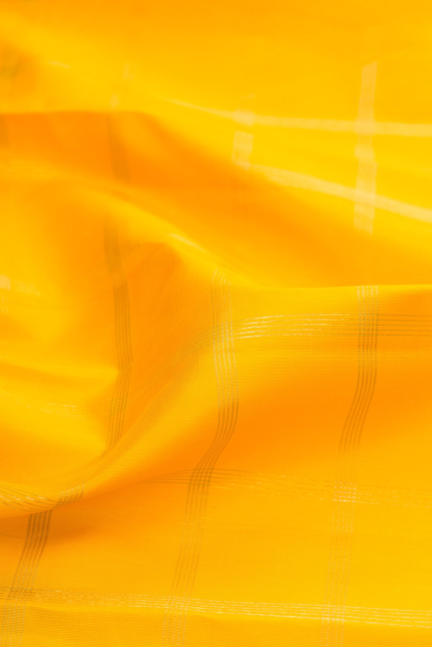 Close up of Pure Silk Pure Zari Yellow Kanjivaram Saree with Checked design on the body and Temple Border.  displaying folds