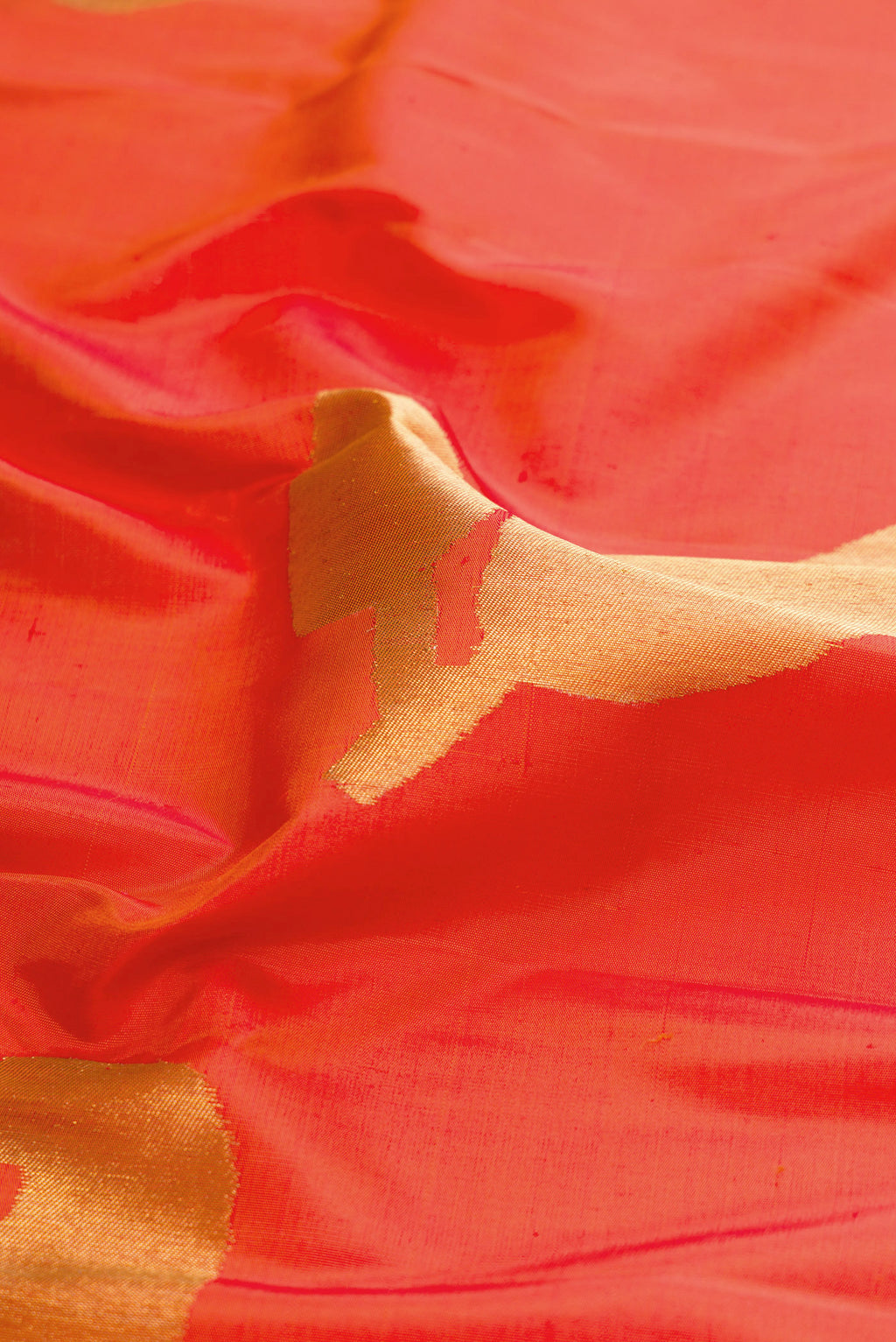 Close up of Pure Silk Pure Zari Orange Kanjivaram Saree with Zari Butta on the body and Checks Border.  displaying folds