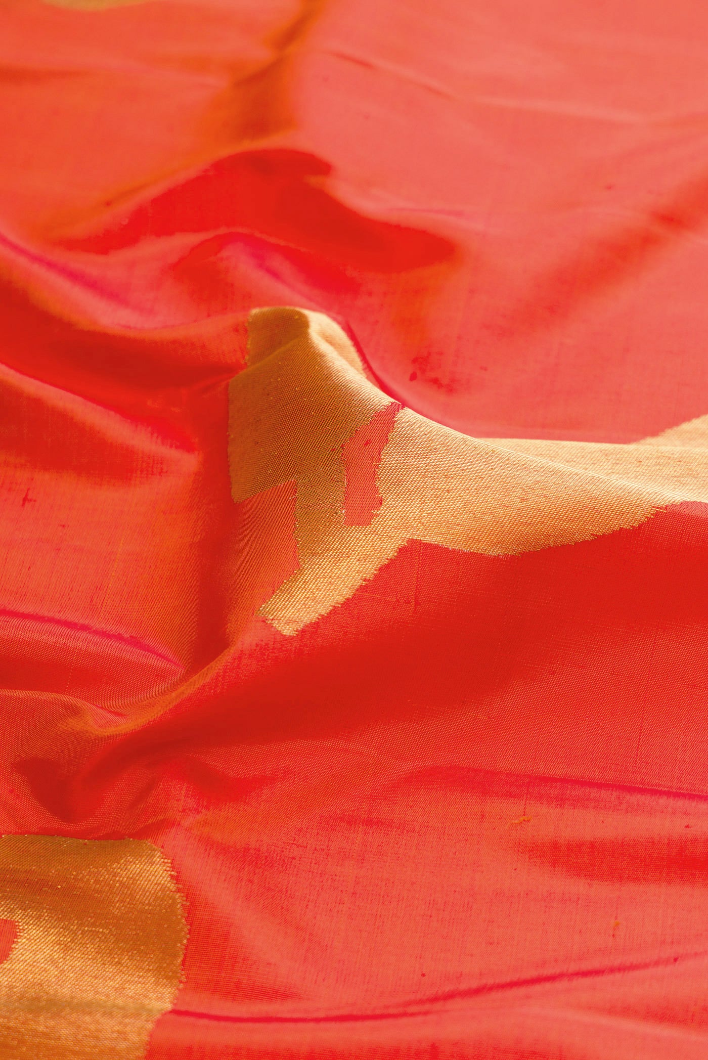 Close up of Pure Silk Pure Zari Orange Kanjivaram Saree with Zari Butta on the body and Checks Border.  displaying folds