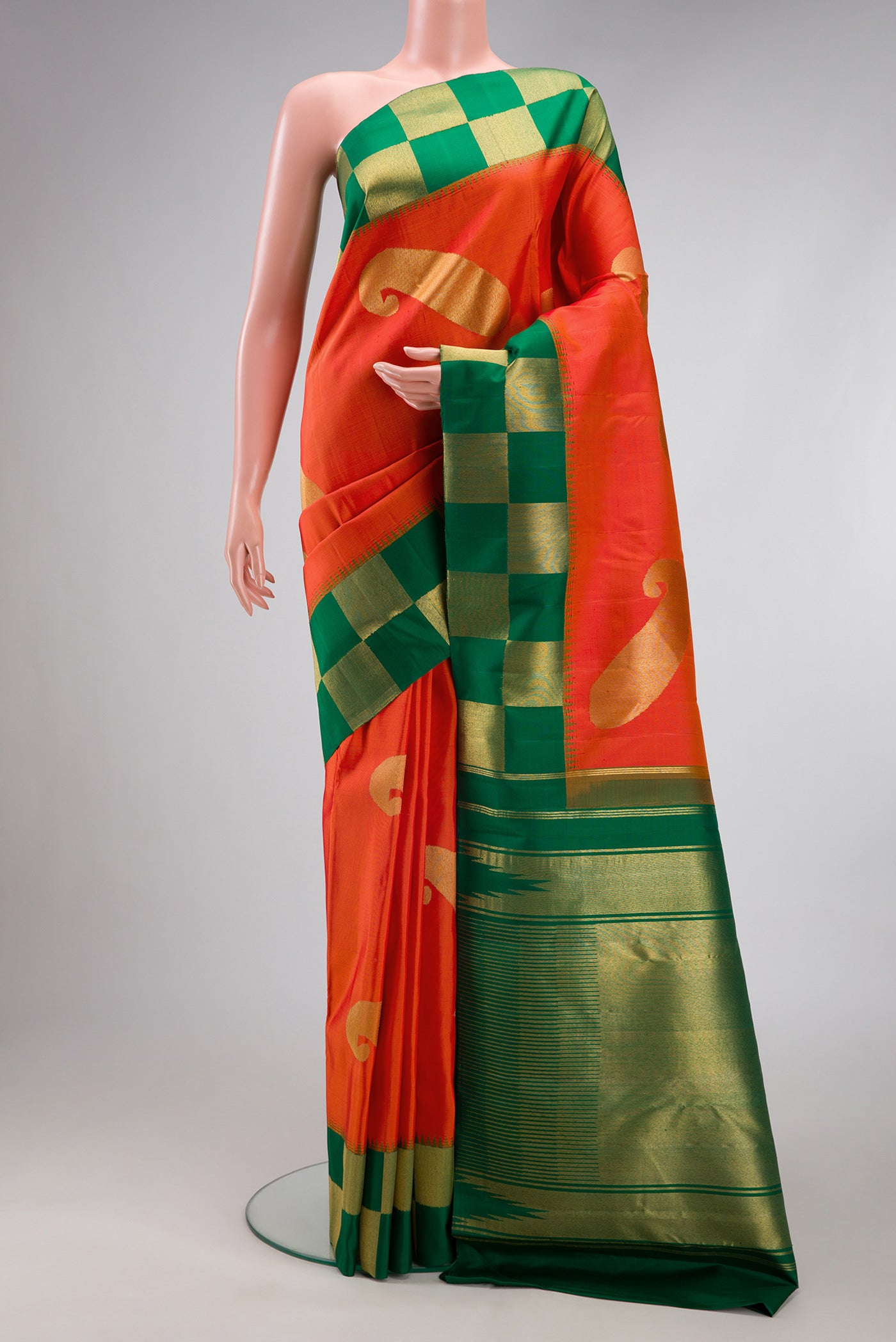 Pure Silk Pure Zari Orange Kanjivaram Saree with Zari Butta on the body and Checks Border.  displayed on a mannequin