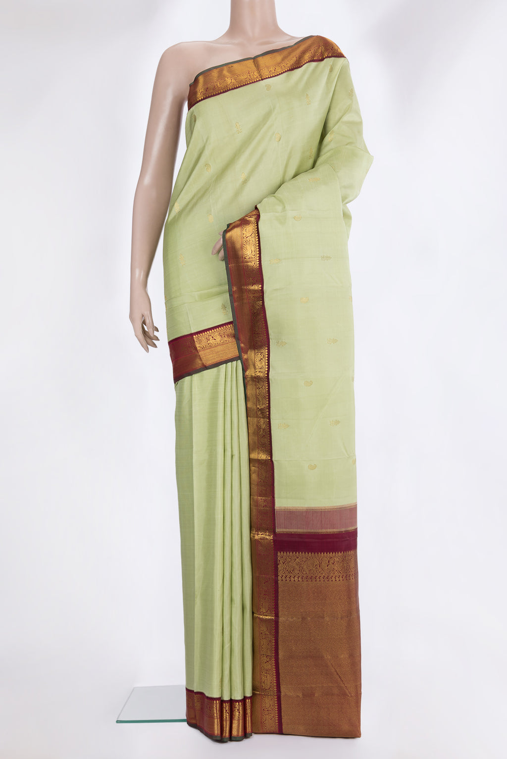 Pure Silk Pista Green Kanjivaram Saree with Zari Butta on the body and Zari Border.  displayed on a mannequin