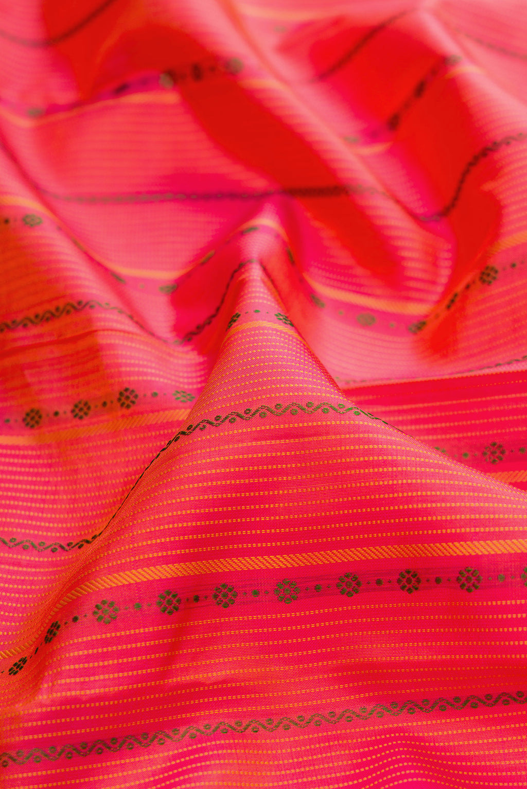 Close up of Pure Silk Coral Kanchipuram Saree with Stripes on the body and Thin Zari Line.  displaying folds