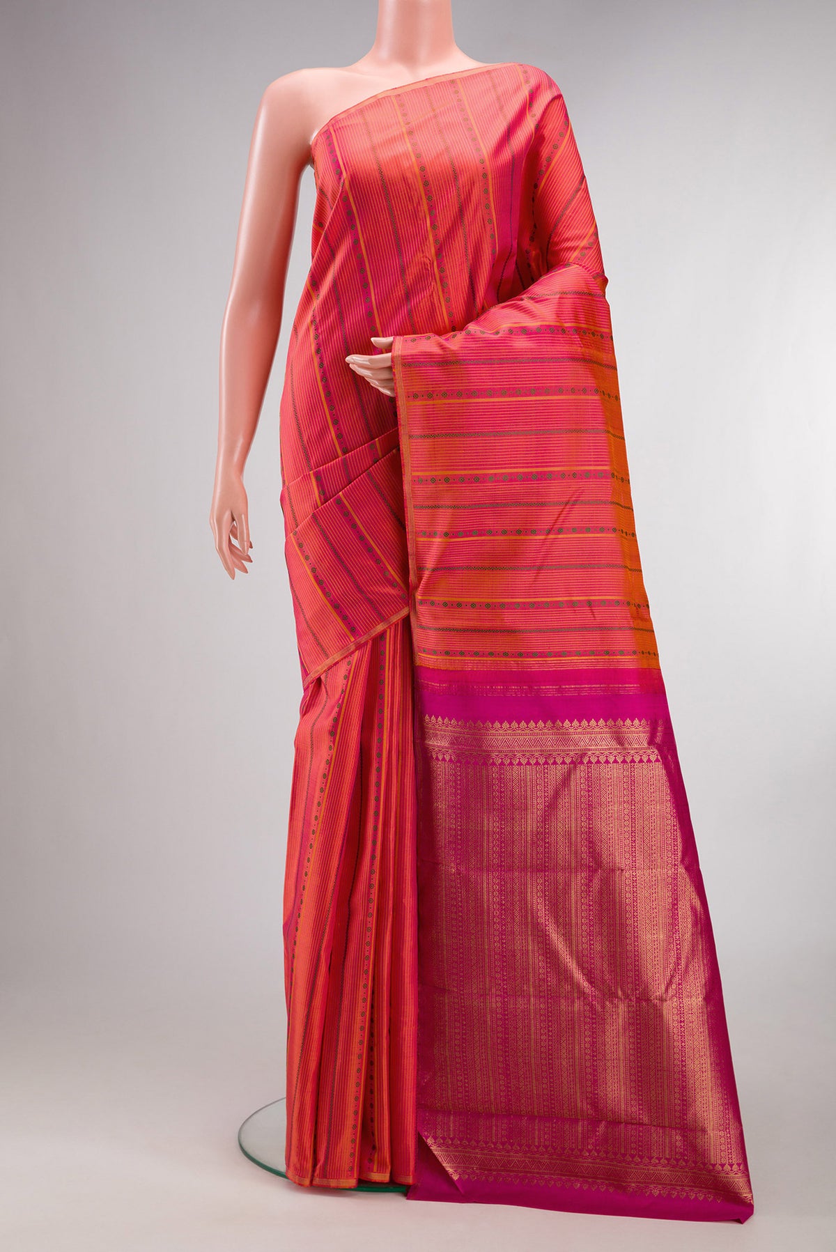 Pure Silk Coral Kanchipuram Saree with Stripes on the body and Thin Zari Line.  displayed on a mannequin