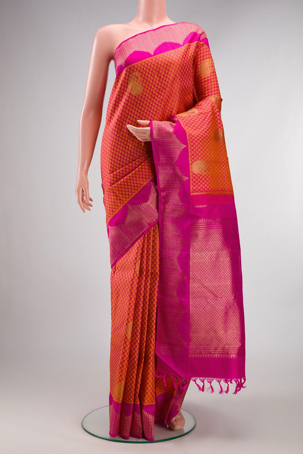 Pure Silk Orange Dual Tone Kanchipuram Saree with Jacquard design on the body and Fancy Border.  displayed on a mannequin