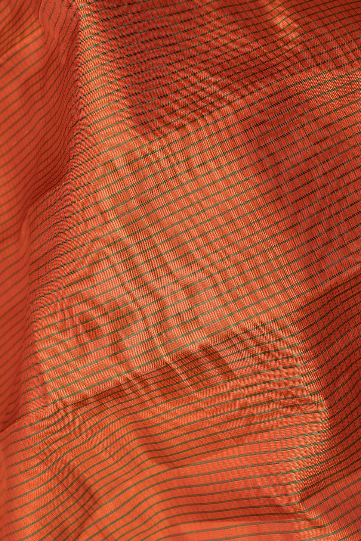 Close up of Pure Silk Orange Kanjivaram Saree with Checked design on the body and Fancy Border.  displaying folds