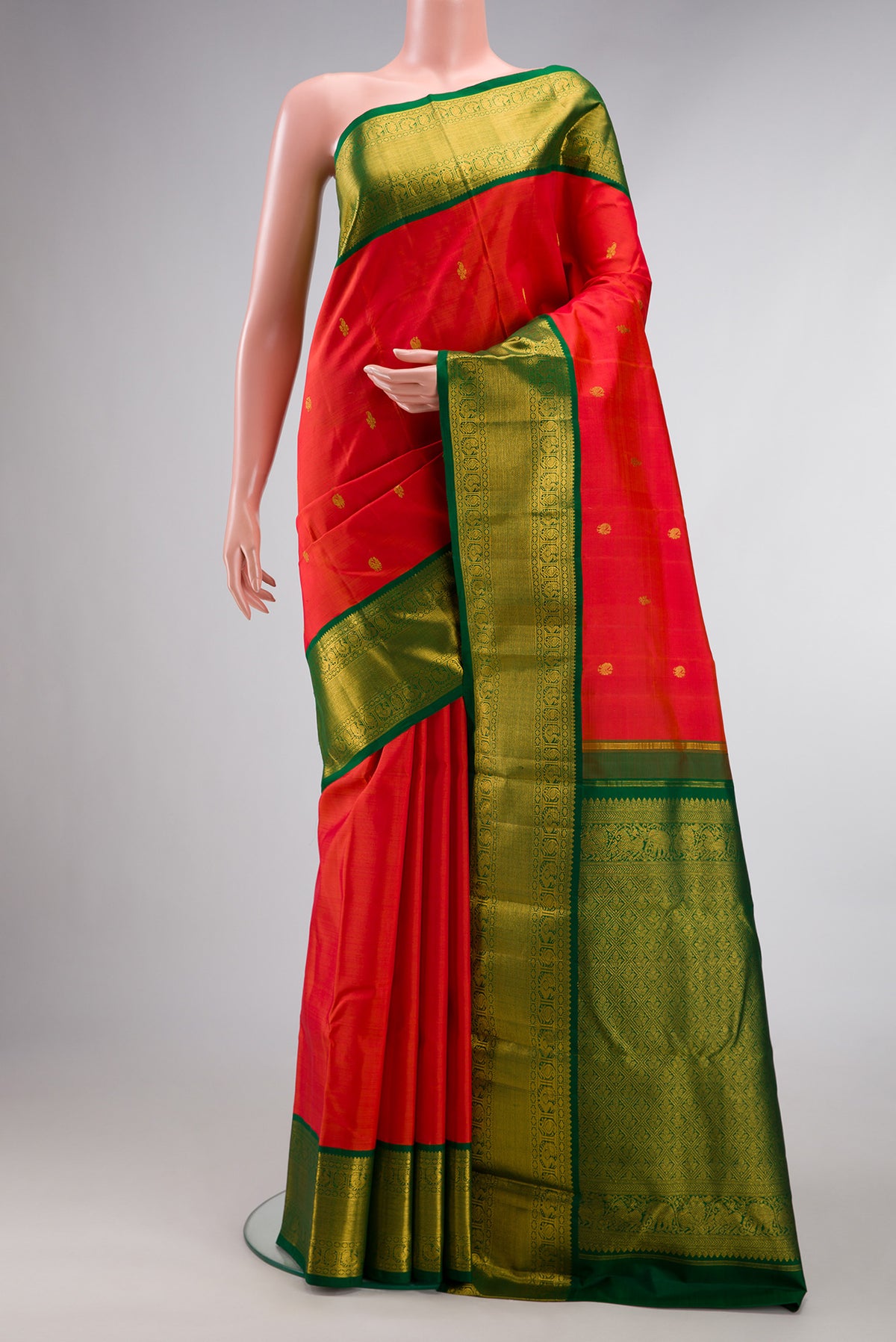 Pure Silk Orange Kanjivaram Saree with Zari Butta on the body and Zari Border.  displayed on a mannequin