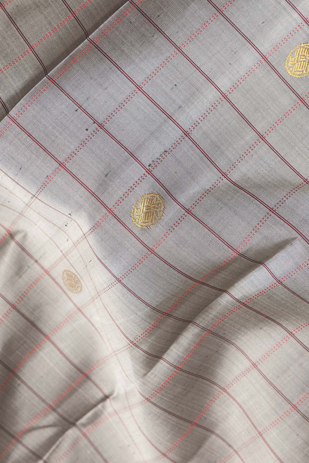 Close up of Pure Silk Grey Dual Tone Kanjivaram Saree with Checked design on the body and Zari Border.  displaying folds