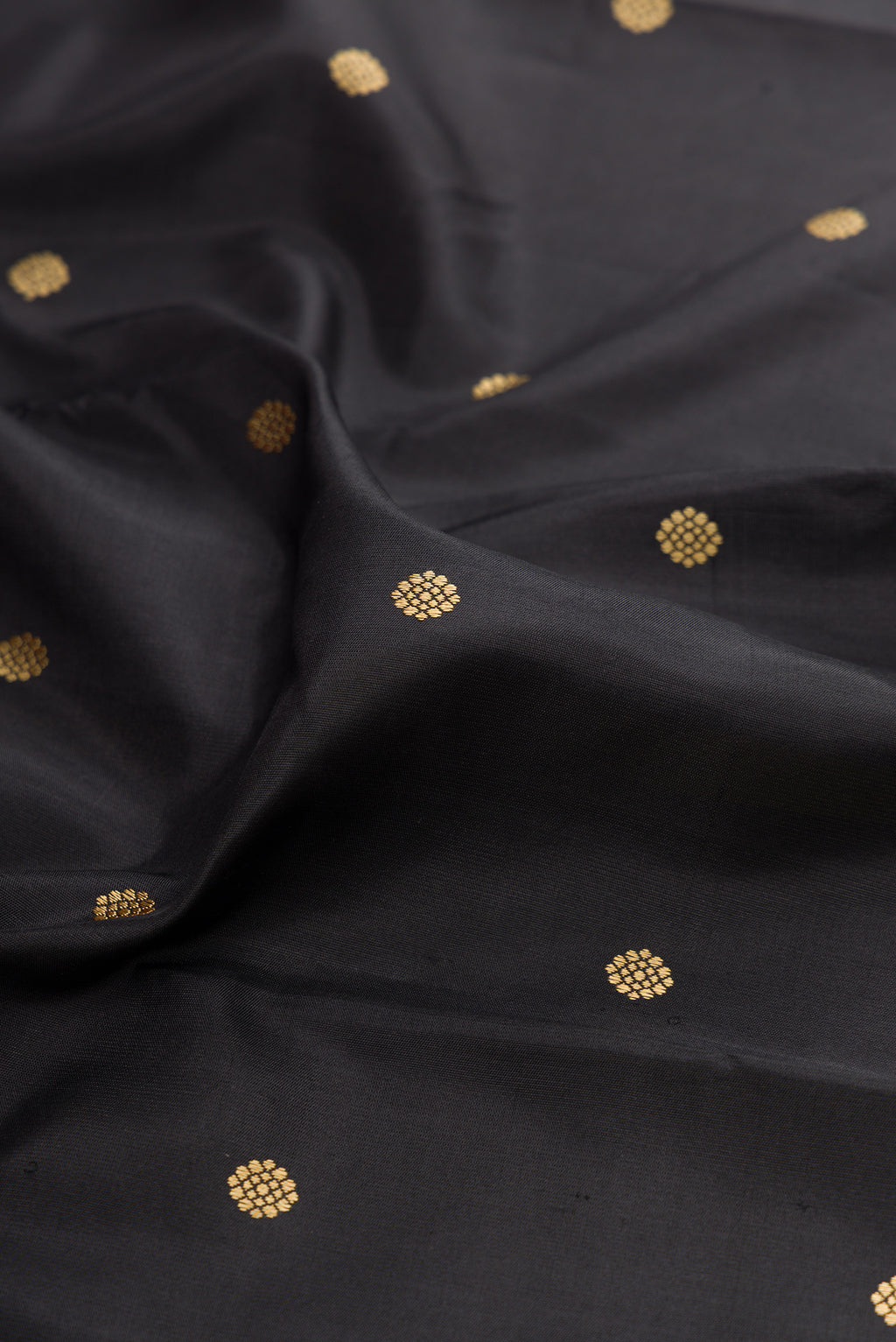Close up of Black Kanchipuram Silk Saree with Thread Butta on the body and Thread Border.  displaying folds