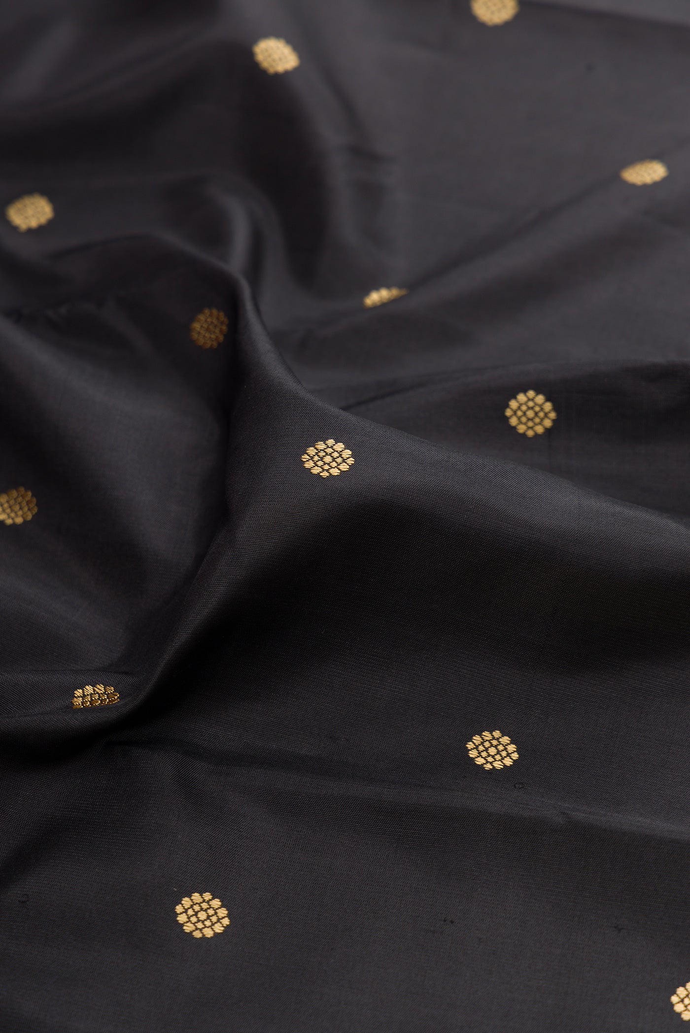 Close up of Black Kanchipuram Silk Saree with Thread Butta on the body and Thread Border.  displaying folds