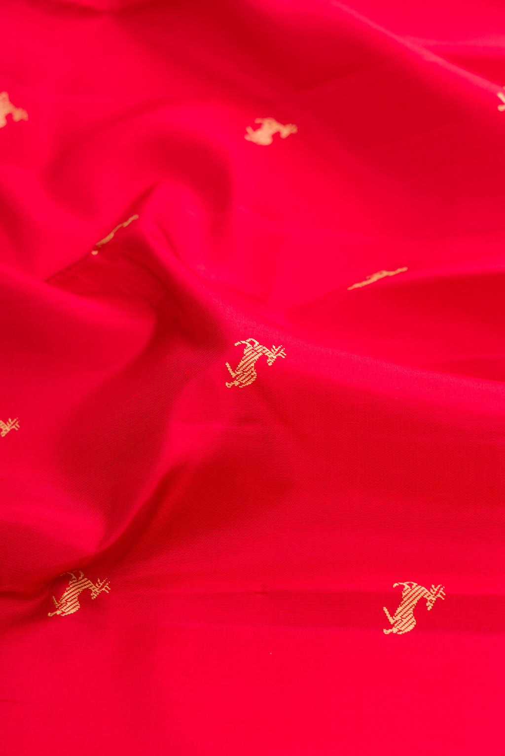 Close up of Red Kanchipuram Silk Saree with Thread Butta on the body and Thread Border.  displaying folds
