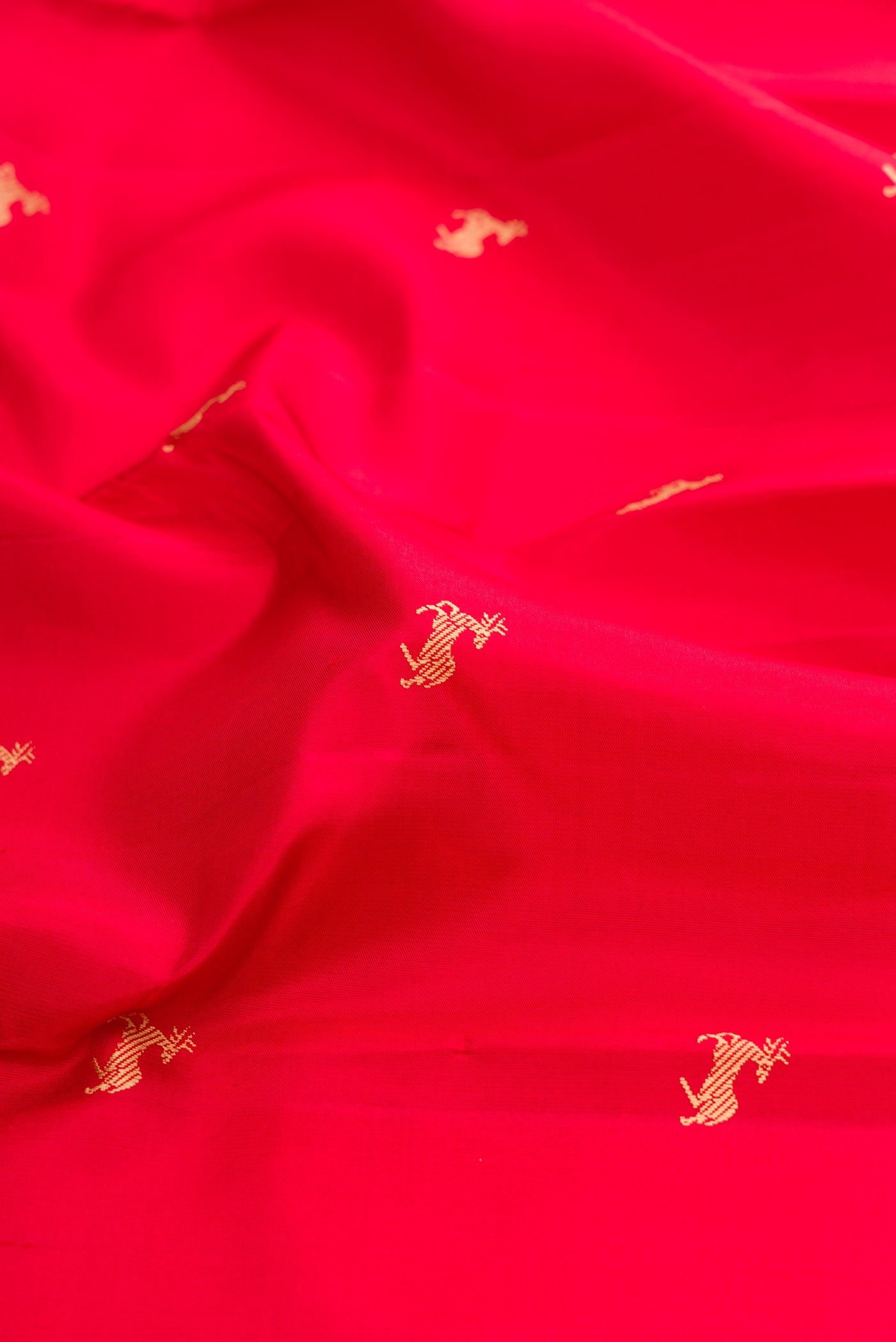 Close up of Red Kanchipuram Silk Saree with Thread Butta on the body and Thread Border.  displaying folds