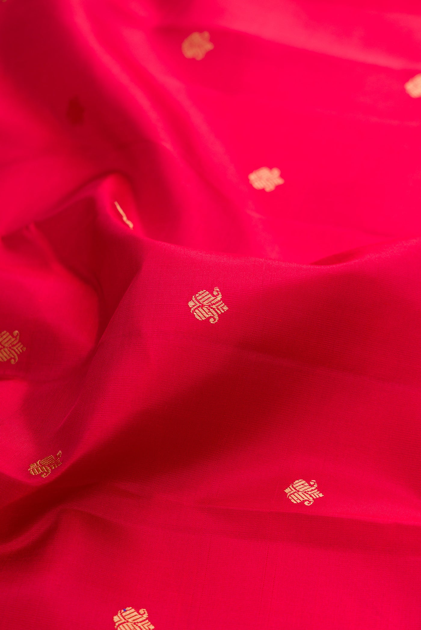 Close up of Red Kanchipuram Silk Saree with Thread Butta on the body and Thread Border.  displaying folds