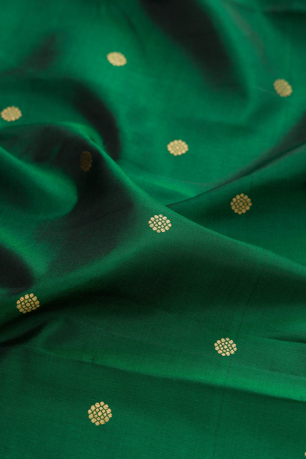 Close up of Bottle Green Kanchipuram Silk Saree with Thread Butta on the body and Thread Border.  displaying folds