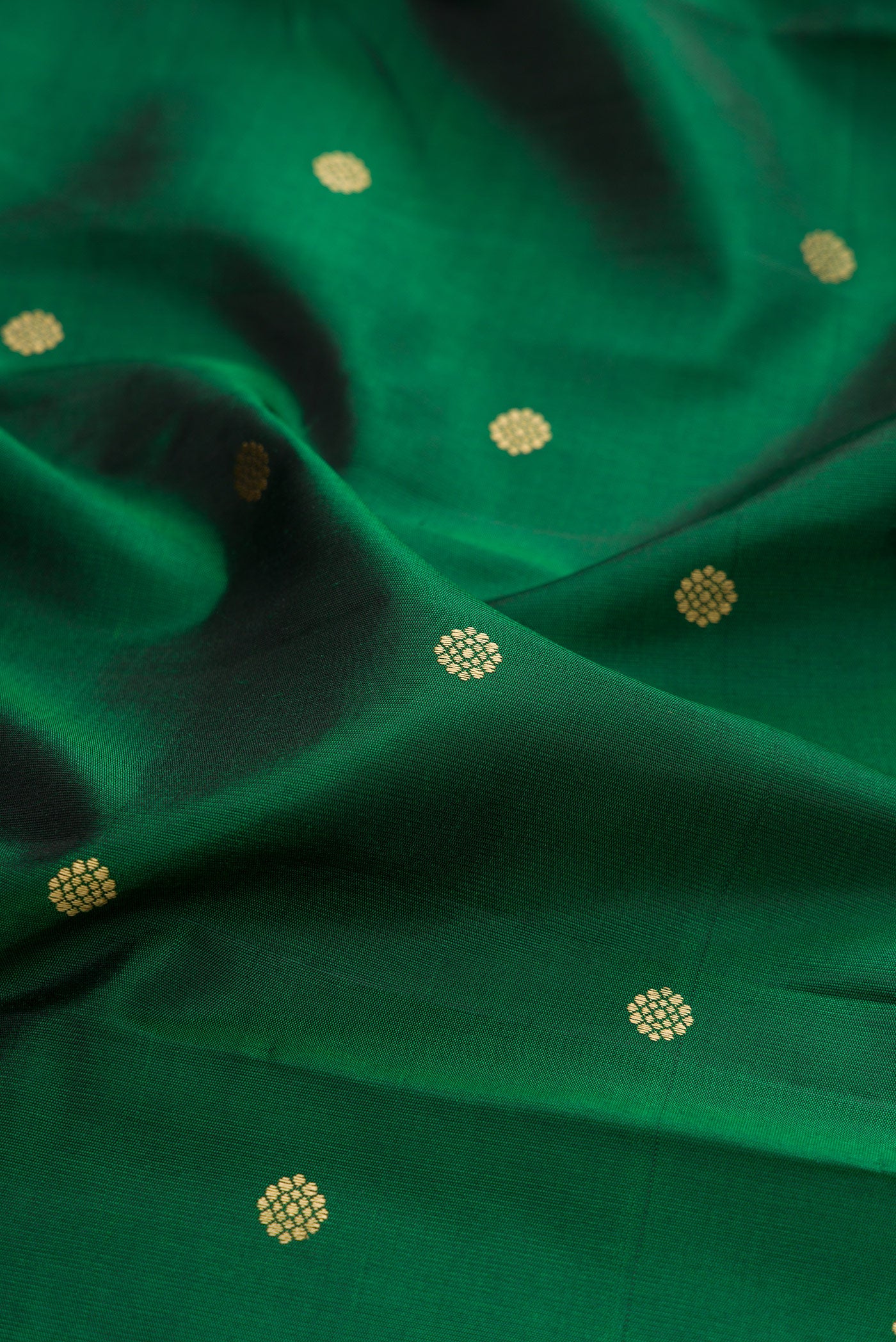Close up of Bottle Green Kanchipuram Silk Saree with Thread Butta on the body and Thread Border.  displaying folds