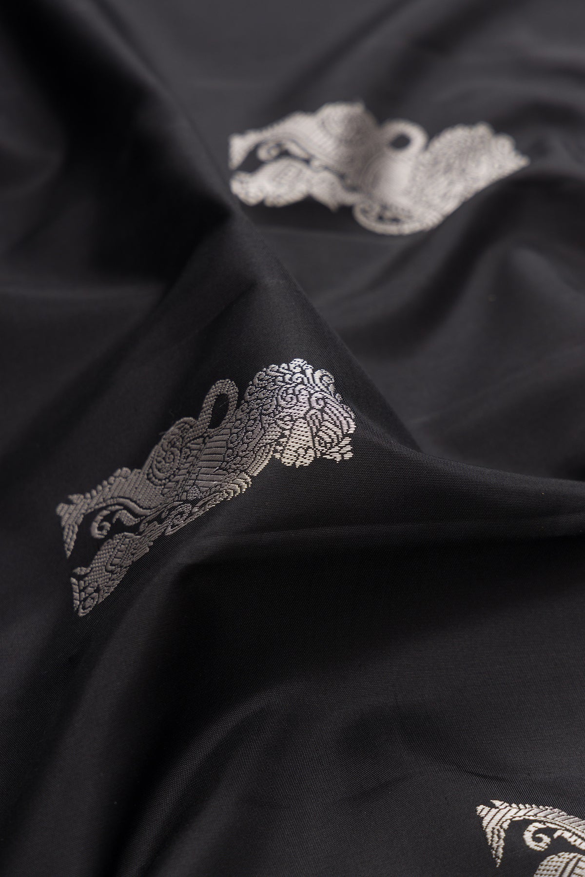 Close up of Pure Silk Black Dual Tone Kanjivaram Saree with Thread Butta on the body and Fancy Border.  displaying folds