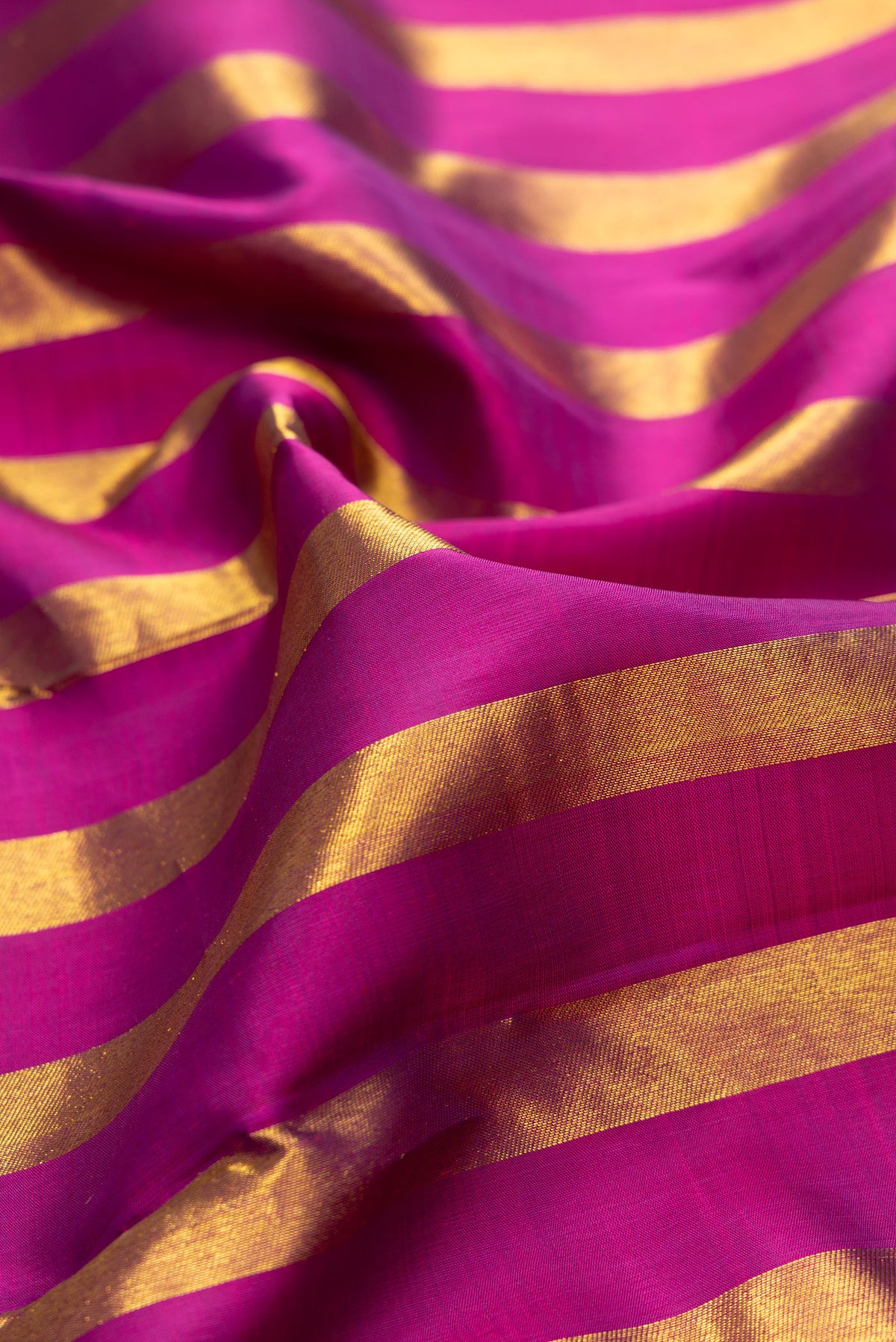 Close up of Pure Silk Light Magenta Dual Tone Kanjivaram Saree with Stripes on the body and Without Border.  displaying folds